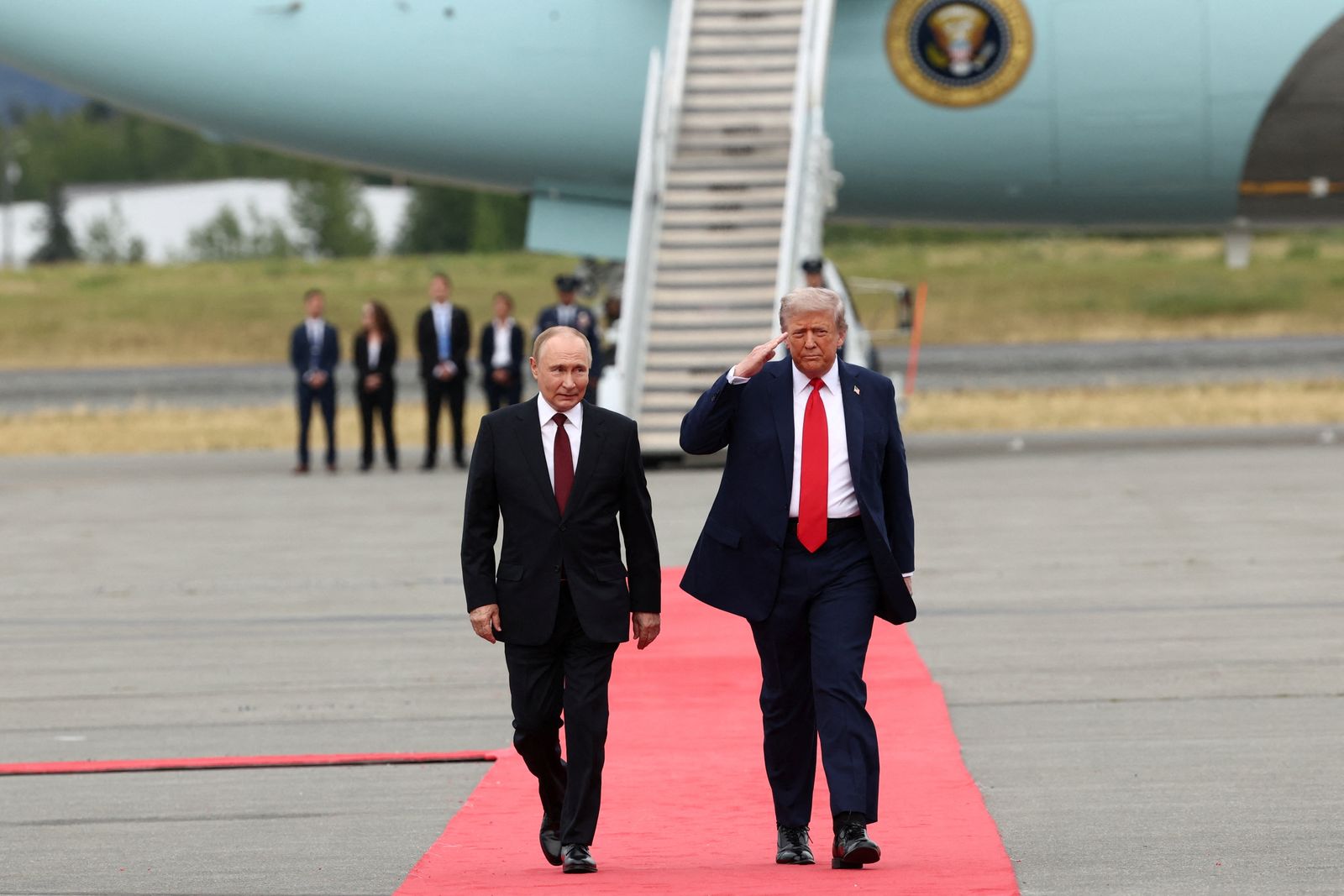 U.S. President Donald Trump salutes, while he walks with Russian President Vladimir Putin, as they meet to negotiate for an end to the war in Ukraine, at Joint Base Elmendorf-Richardson in Anchorage, Alaska, U.S., August 15, 2025. REUTERS/Kevin Lamarque