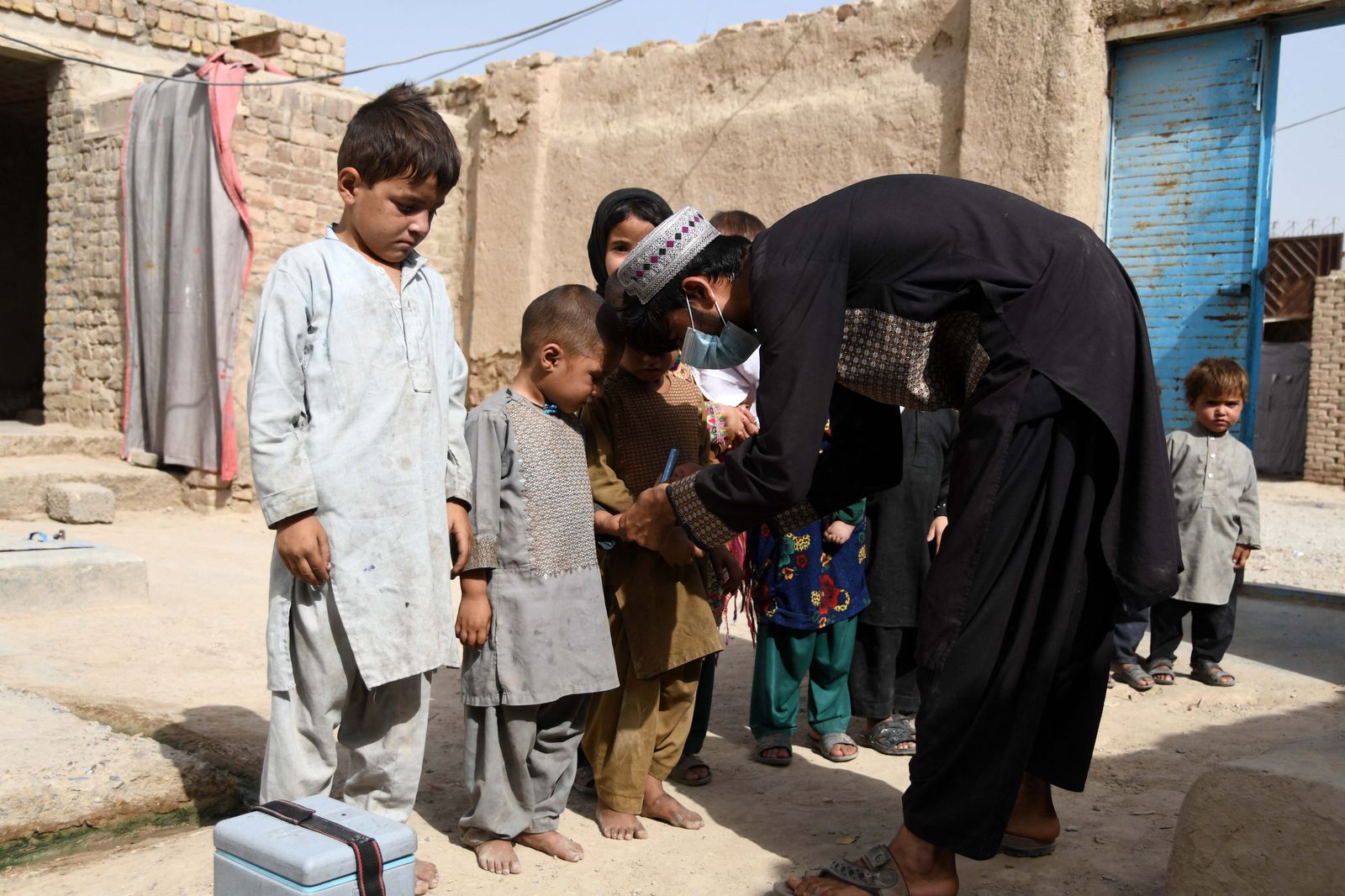 A health worker marks a child's finger with ink after giving polio vaccine at a campaign in Kandahar on June 28, 2022. (Photo by Javed TANVEER / AFP) - AFP