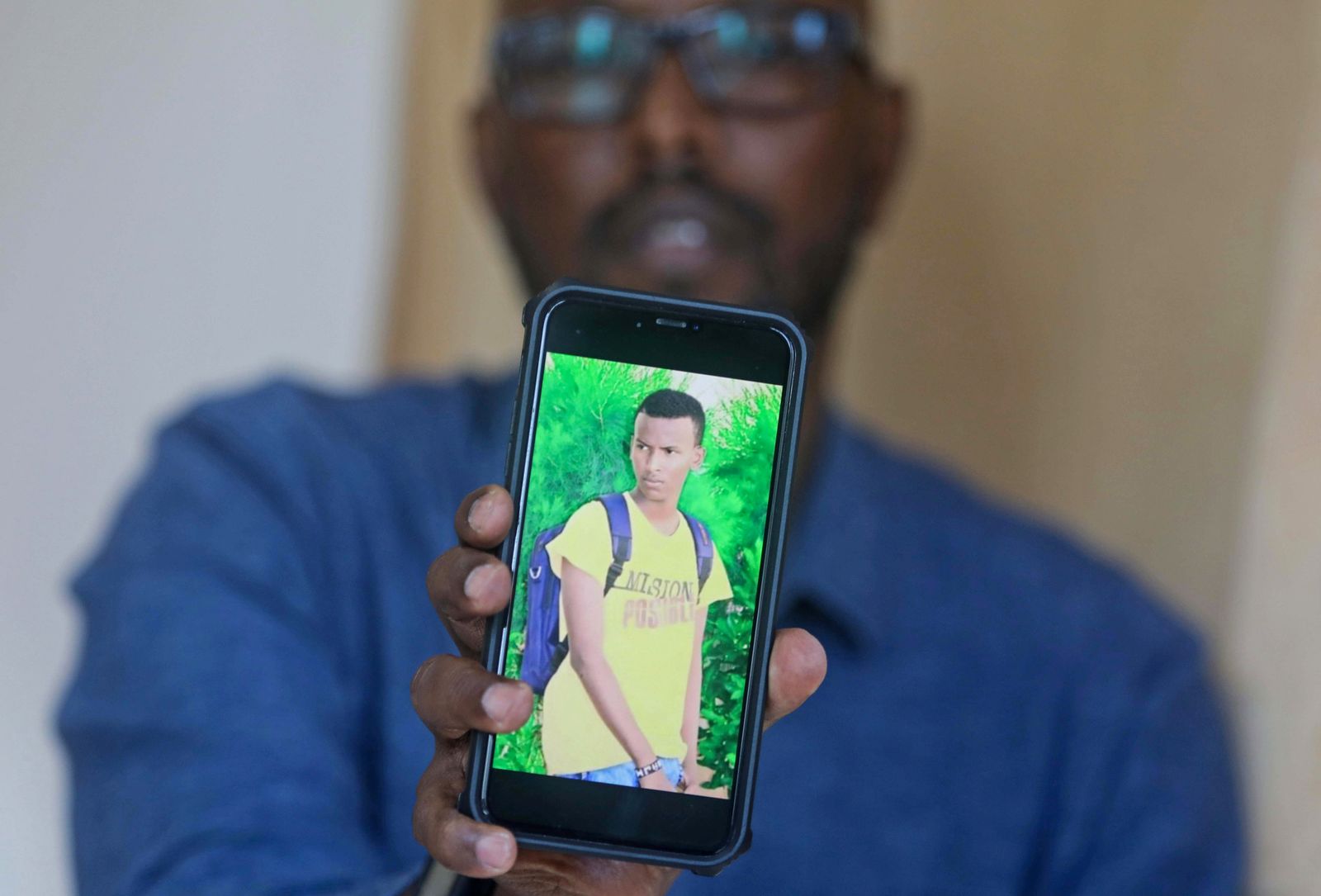 عبد السلام جوليد يحمل هاتفاً عليه صورة ابنه المفقود وذلك خلال مقابلة مع وكالة 