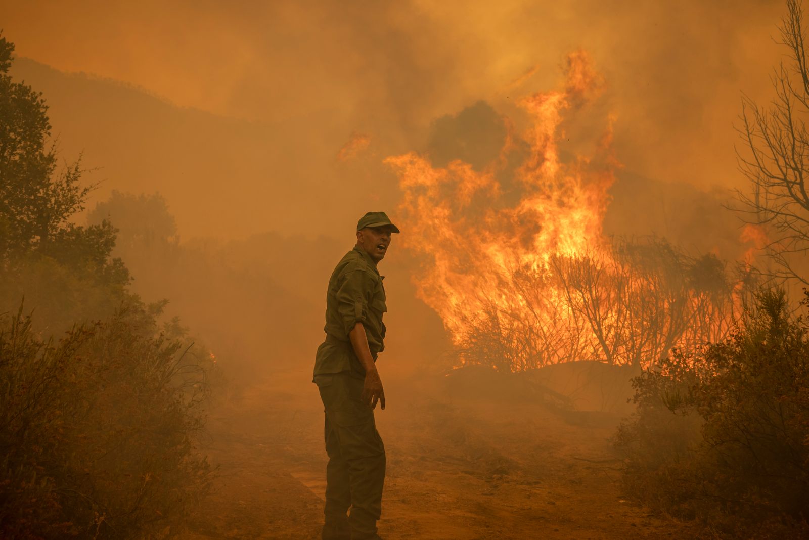 A Moroccan soldier reacts next to a forest fire near Ksar el-Kebir in the Larache region, on July 15, 2022. (Photo by FADEL SENNA / AFP) - AFP