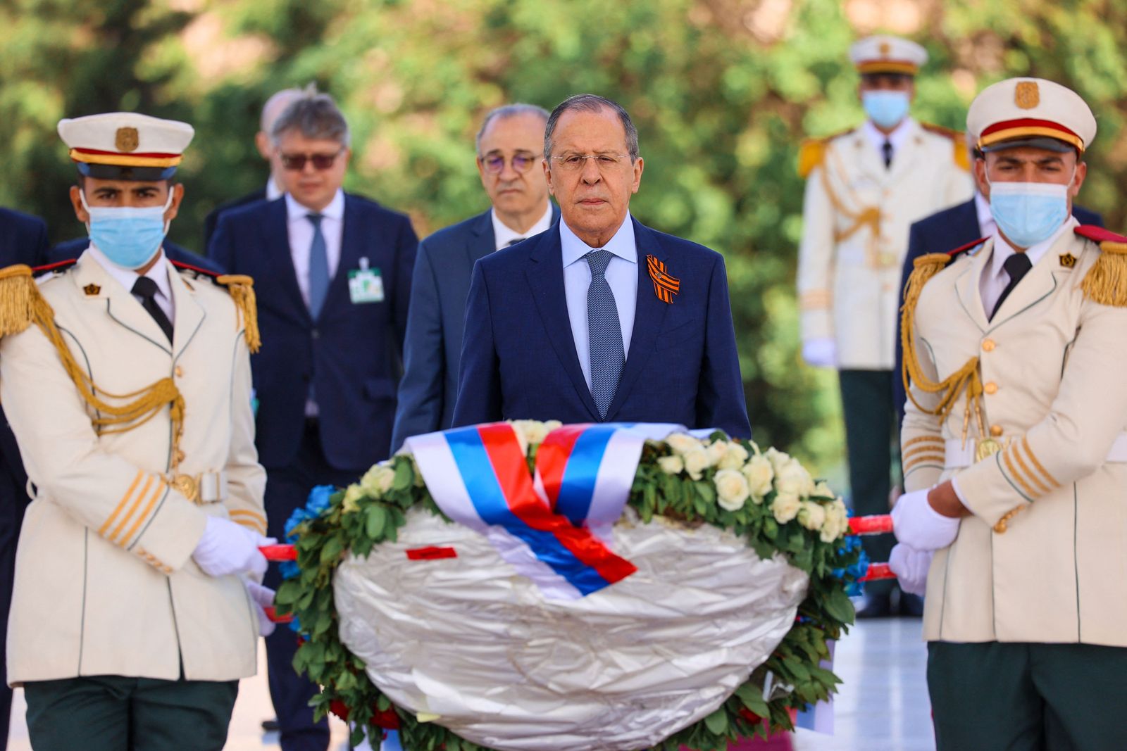 A handout picture taken and released by the Russian Foreign Ministry press service shows Russian Foreign Minister Sergei Lavrov (C) attends a flower-laying ceremony during his visit in Algiers on May 10, 2022. (Photo by Handout / various sources / AFP) / RESTRICTED TO EDITORIAL USE - MANDATORY CREDIT 