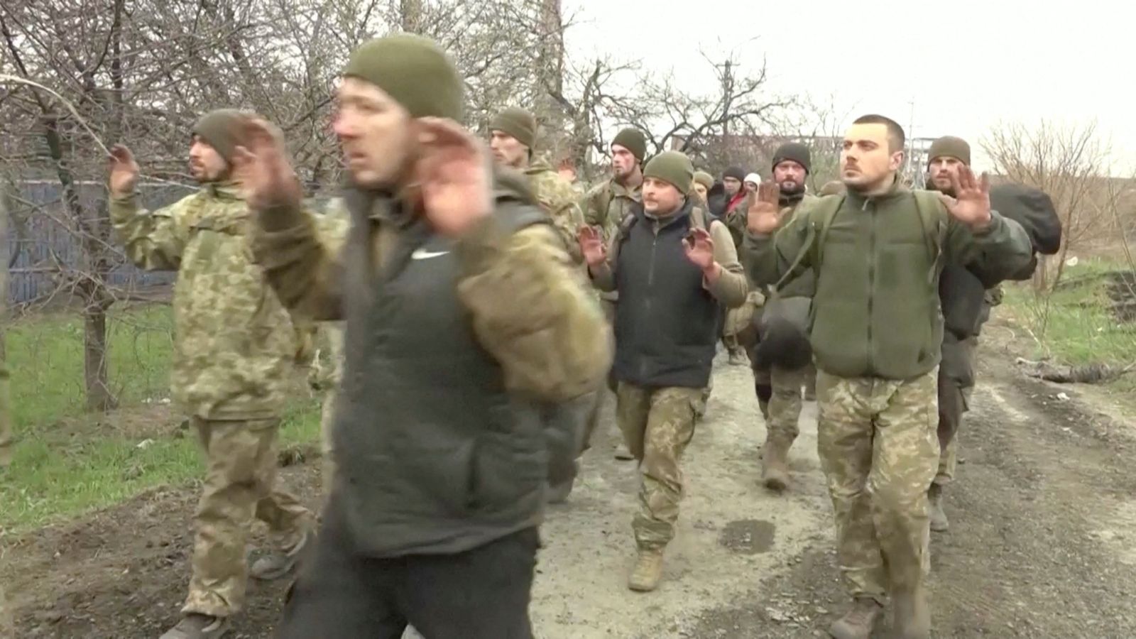 Soldiers walk with their hands raised in a location given as Mariupol - via REUTERS