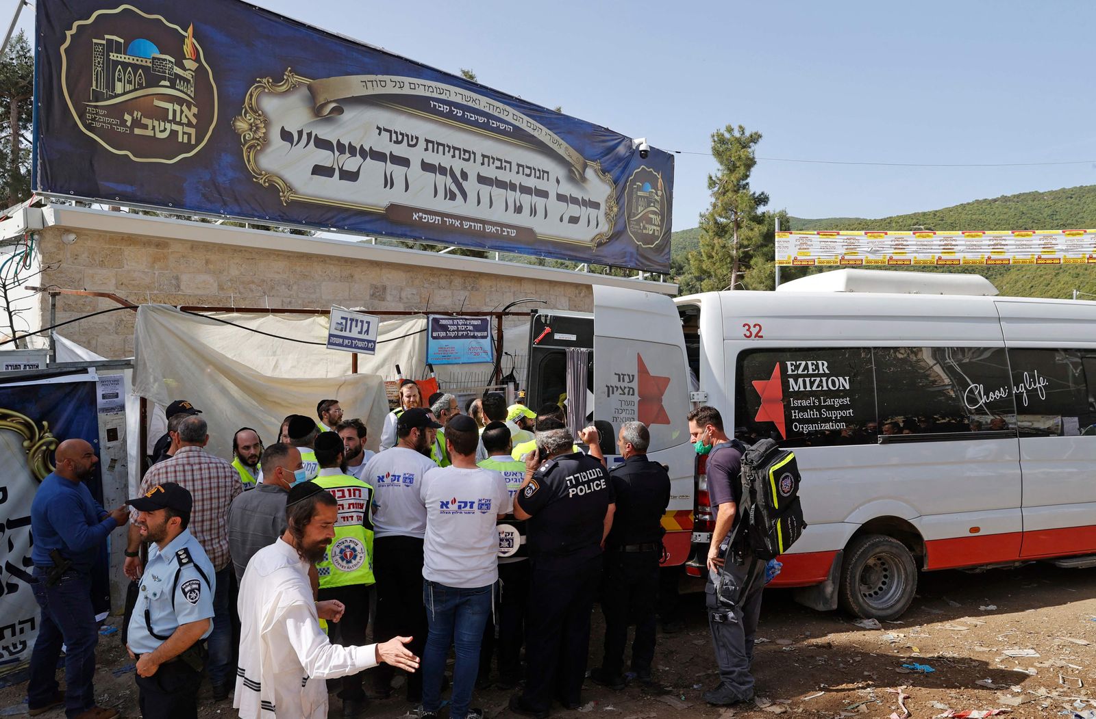 Israeli rescue teams transport victims into an ambulance on April 30, 2021 at the scene of a stampede that took place overnight during a religious gathering in the northern Israeli town of Meron near the reputed tomb of Rabbi Shimon Bar Yochai, a second-century Talmudic sage, where mainly ultra-Orthodox Jews flock to mark the Lag BaOmer holiday. - A massive stampede at the densely packed Jewish pilgrimage site killed at least 44 people in northern Israel early in the morning, with rescue workers facing chaotic crowds while trying to evacuate the injured. (Photo by JACK GUEZ / AFP) - AFP