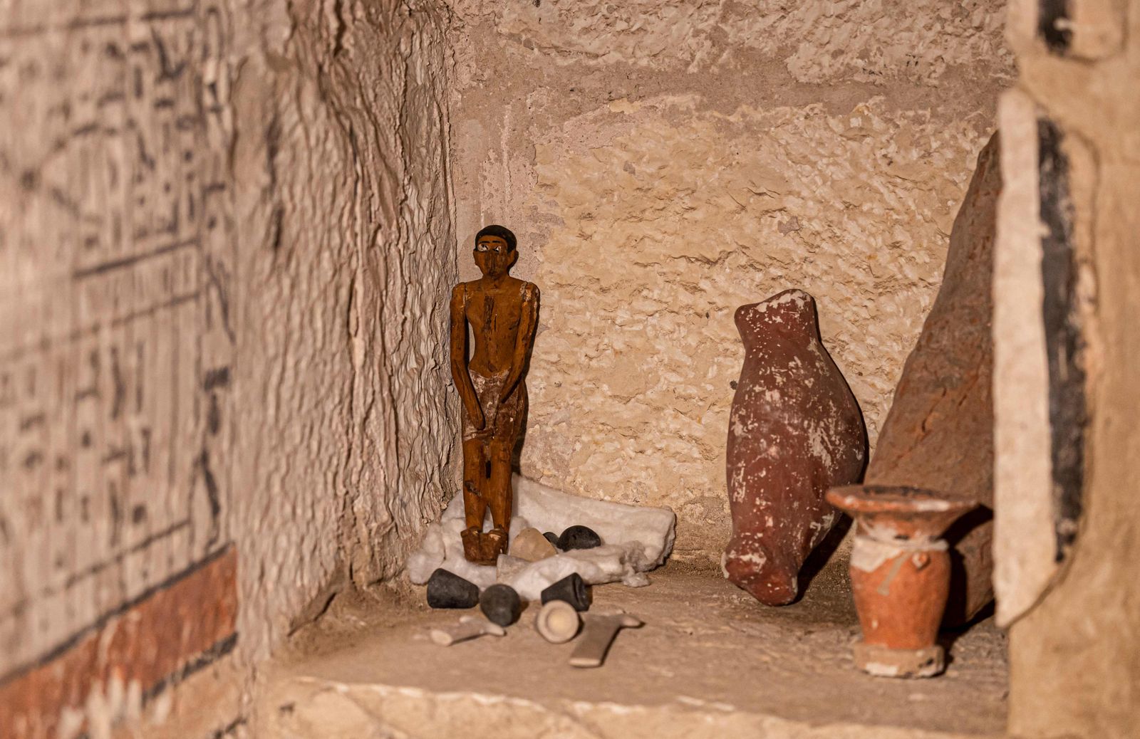 تمثال فرعوني وقطع أثرية أخرى داخل إحدى المقابر الخمس المكتشفة. 19 مارس 2022 - AFP