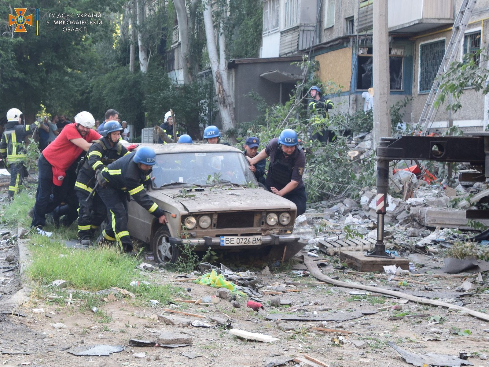عمال الإنقاذ ينقلون سيارة بالقرب من مبنى سكني تعرض لضربة روسية في ميكولايف الأوكرانية، 29 يونيو 2022.  - via REUTERS