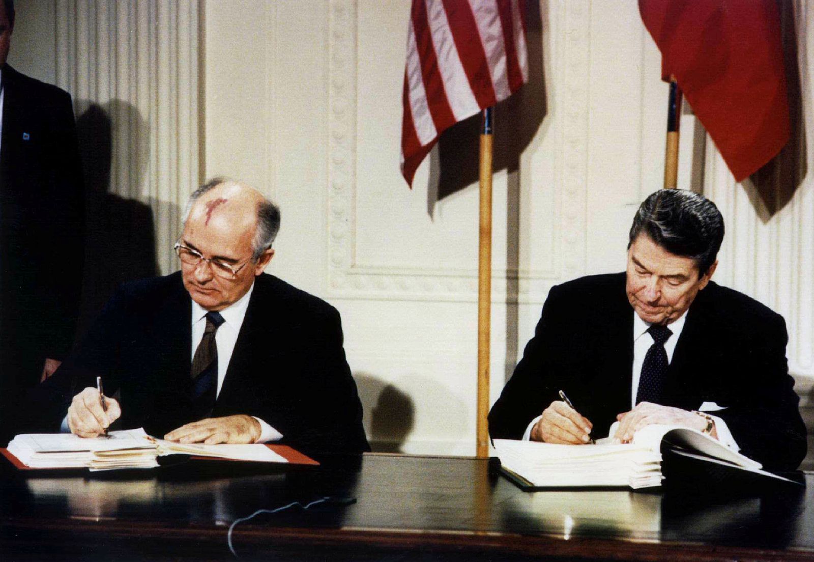 الرئيس الأميركي الراحل رونالد ريغان (يمين) والزعيم السوفياتي ميخائيل غورباتشوف يوقّعان معاهدة القوات النووية متوسطة المدى في البيت الأبيض - 8 ديسمبر 1987 - REUTERS