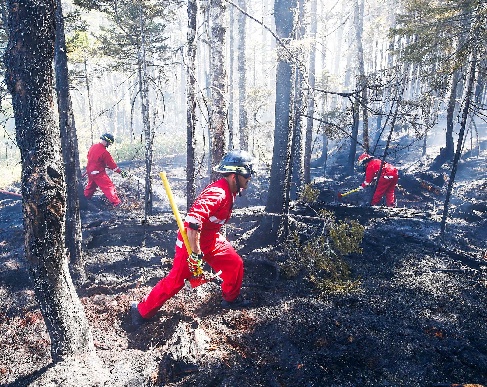 In this May 30, 2023, image courtesy of the Nova Scotia Government in Canada, firefighters with Halifax Regional Fire and Emergency work to put out fires in the Tantallon area of Nova Scotia. More than 16,000 people were forced to evacuate their homes in Canada's eastern province of Nova Scotia, officials said Monday, as one of hundreds of wildfires raging across the country threatened the city of Halifax. (Photo by Handout / Nova Scotia Government / AFP) / RESTRICTED TO EDITORIAL USE - MANDATORY CREDIT 