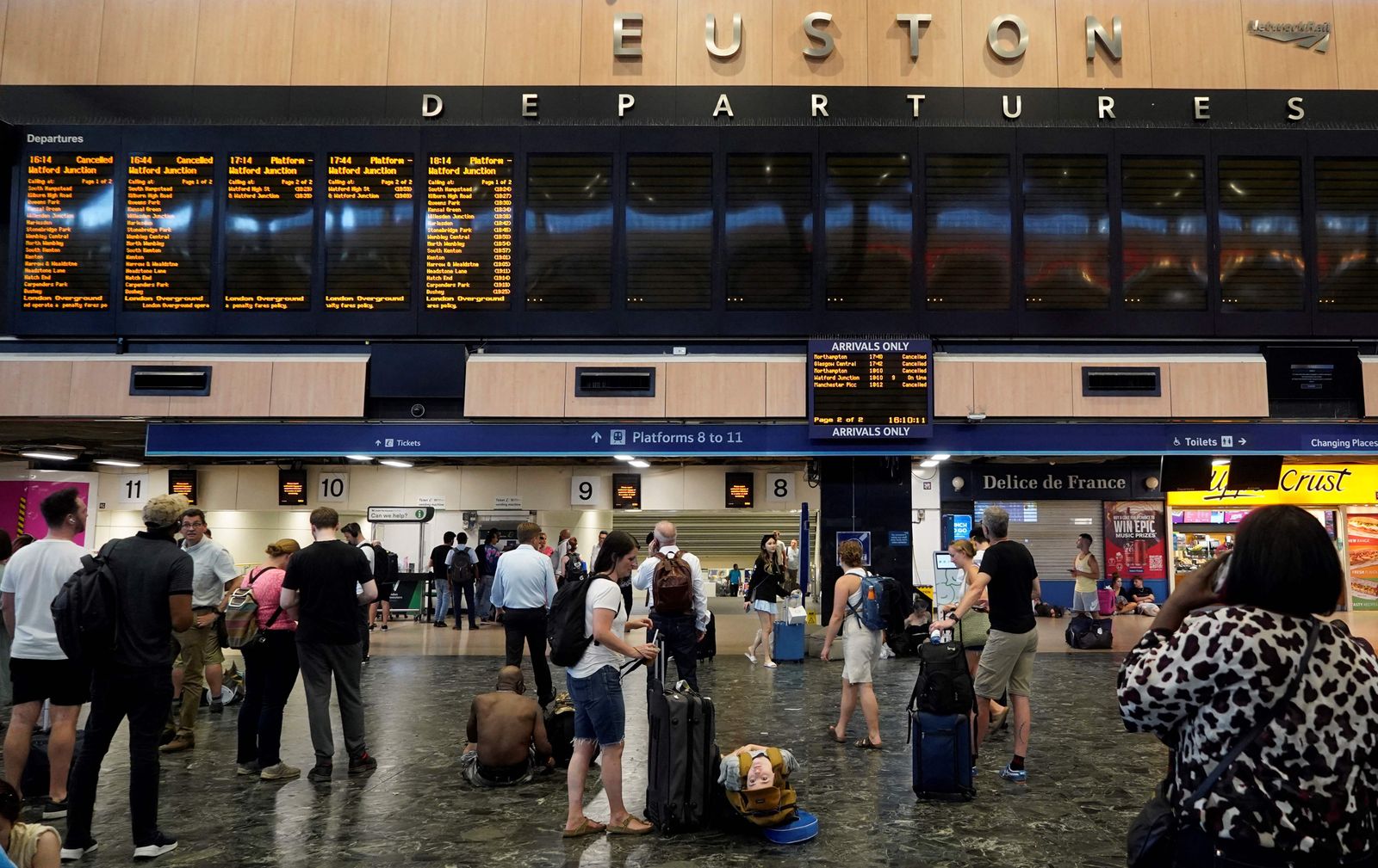 Travellers look at the blank departures board at Euston train station in central London, on July 19, 2022, as services were cancelled due to a trackside fire, and as the country experiences an extreme heat wave. - All services to and from London Euston were on Tuesday suspended, as emergency services dealt with a fire on the trackside. After the UK's warmest night on record, the Met Office said 40.2C had been provisionally recorded by lunchtime at Heathrow Airport, in west London, taking the country into uncharted territory. (Photo by Niklas HALLE'N / AFP) - AFP