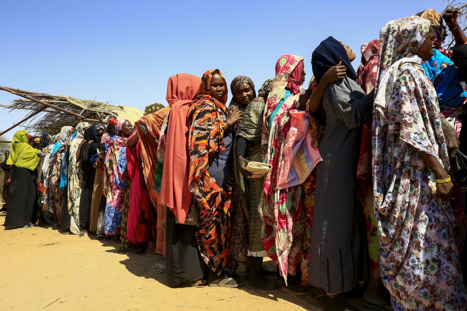 سودانيات نازحات ينتظرن وصول مساعدات برنامج الأغذية العالمي إلى مخيم عطاش للنازحين في ضواحي مدينة نيالا عاصمة جنوب دارفور - 1 فبراير 2021 - AFP
