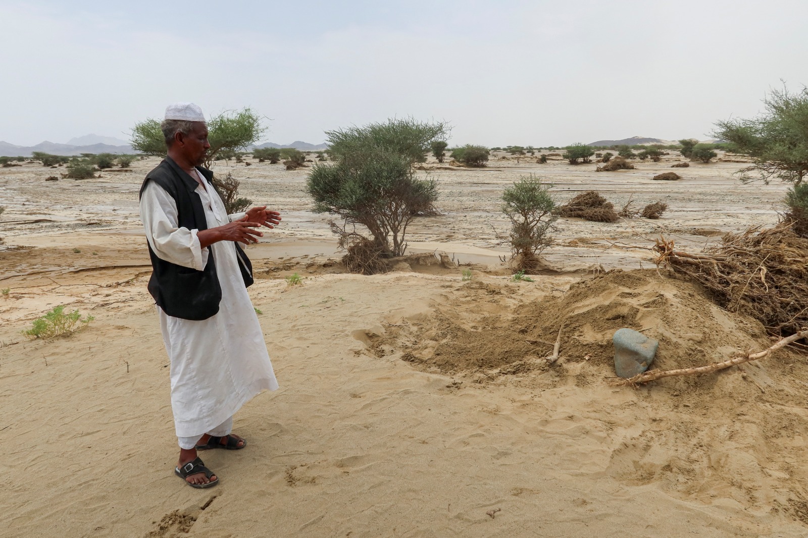 سوداني بجوار قبر قريبه الذي توفي في الفيضانات المدمرة في مدينة بورتسودان. 26 أغسطس 2024