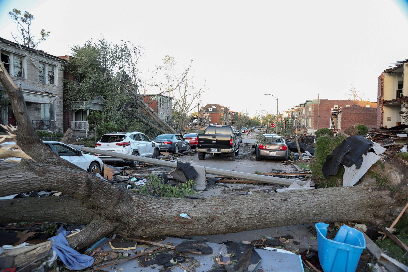 A fallen tree blocks the road next to damaged cars and debris from nearby homes covers the street, after a powerful tornado ripped through the city of St. Louis, Missouri,U.S. May 16, 2025. REUTERS/Lawrence Bryant