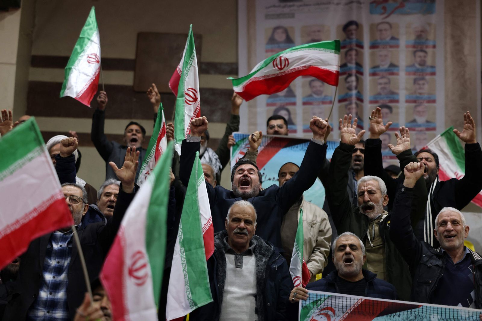 People chant slogans as they attend an electoral campaign rally at a sports stadium ahead of the upcoming elections, in Tehran on February 28, 2024. Iran's supreme leader urged voters to come out in droves on March 1 and show the foes of the Islamic republic a 'strong and fervent' election process for parliament and the key Assembly of Experts. (Photo by ATTA KENARE / AFP)