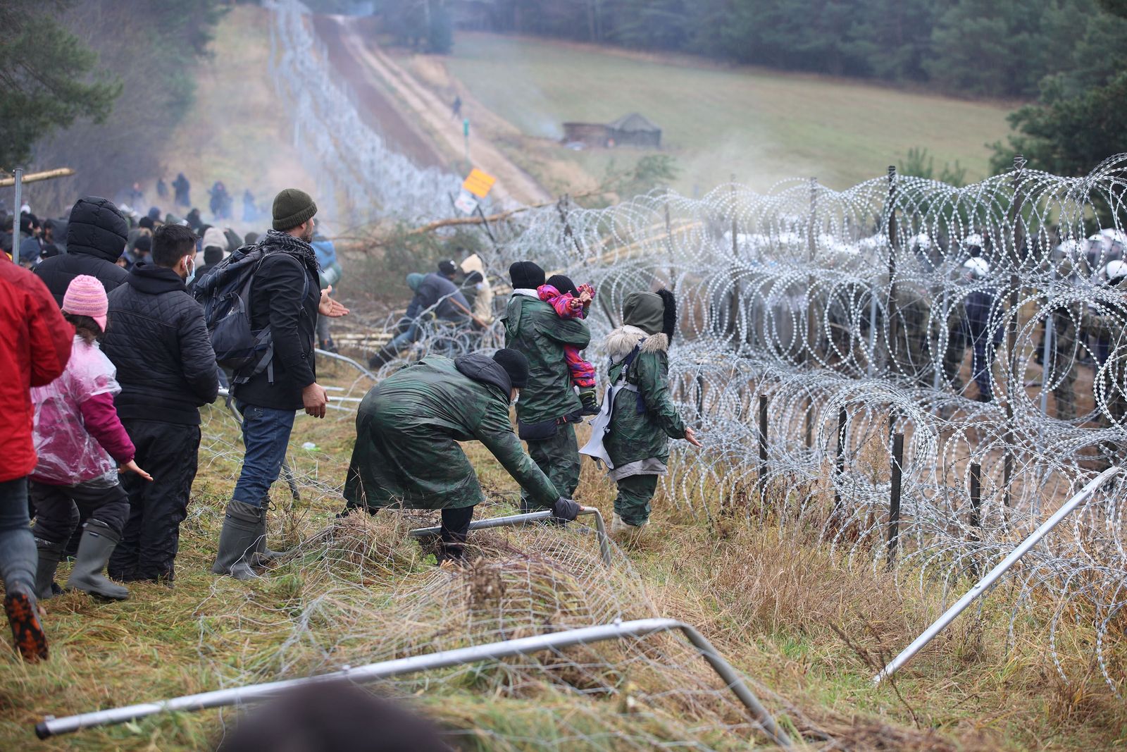 مهاجرون قرب سياج من أسلاك شائكة يحاولون عبور الحدود من بيلاروسيا إلى بولندا - 8 نوفمبر 2021 - REUTERS