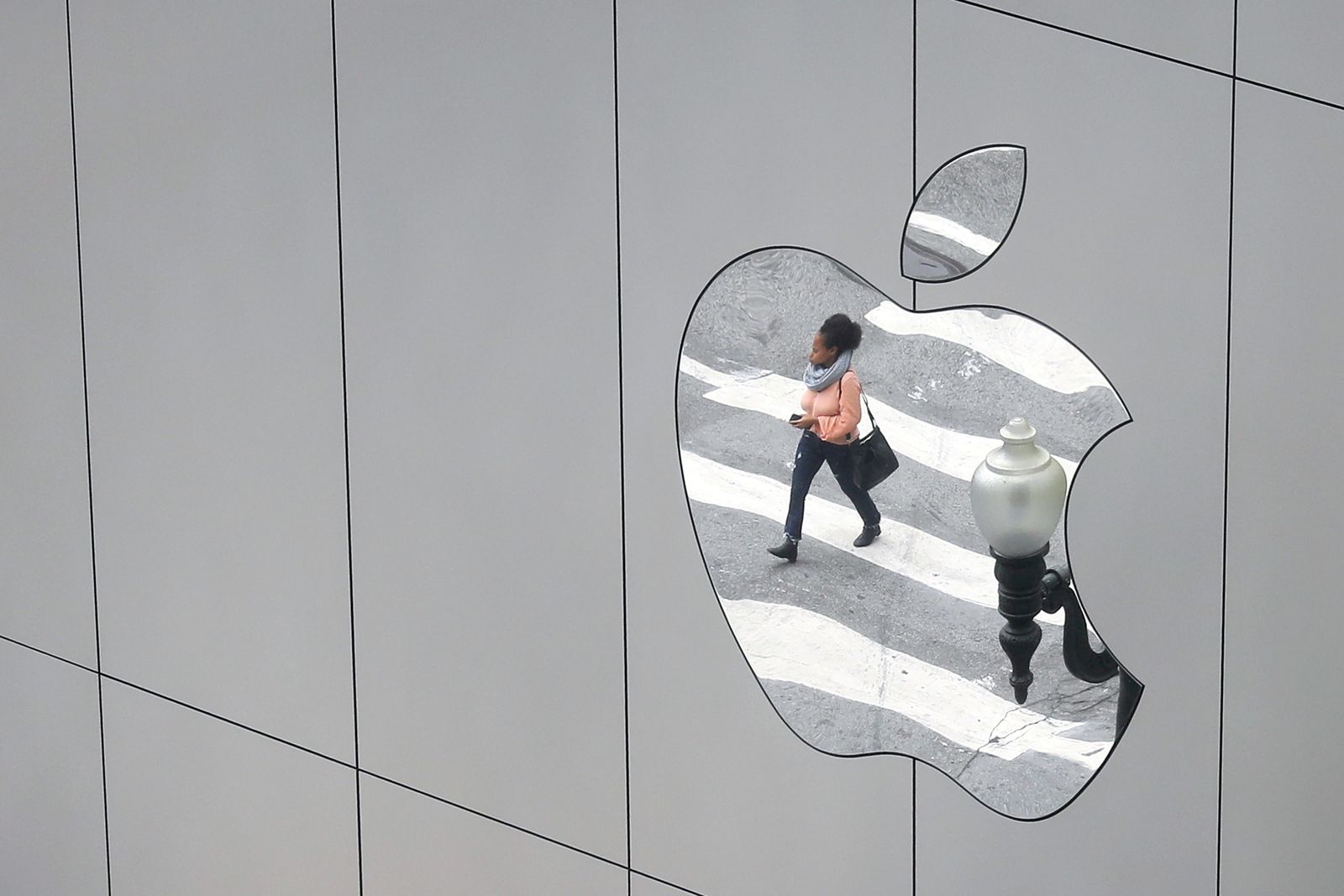 FILE PHOTO: A woman is reflected in a Apple store logo in San Francisco - REUTERS