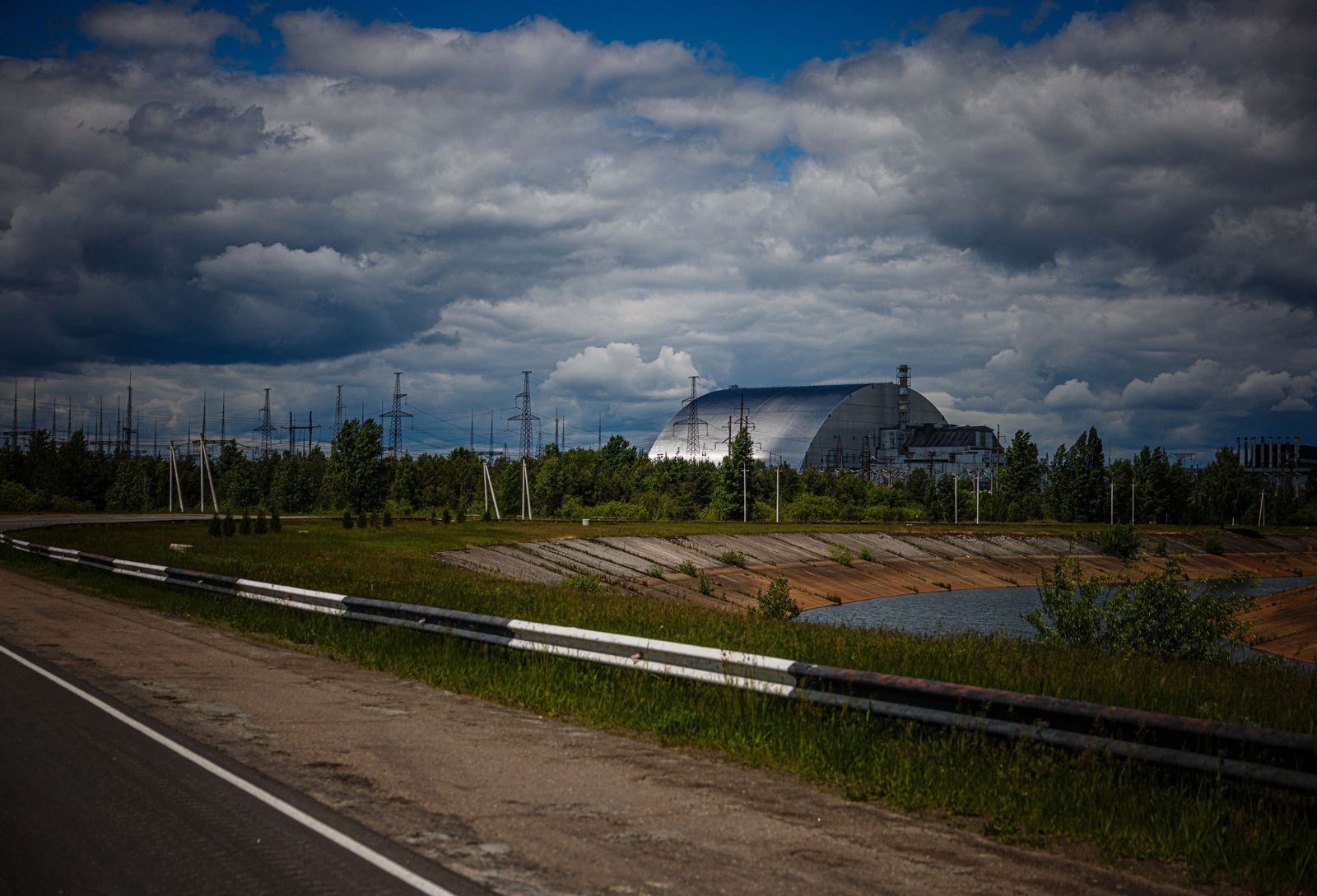 A photograph shows the New Safe Confinement at Chernobyl Nuclear Power Plant which cover the number 4 reactor unit on May 29, 2022, amid the Russian invasion of Ukraine. - More than a 100 employees who had shown up just hours before for their night shift were now trapped as Russian forces crossed into Ukraine and seized swaths of land as they marched toward Kyiv.�The capture of the Chernobyl by Russian forces kicked off a weeks-long ordeal that saw power briefly cut at the facility and employees carefully monitored by the invaders as they grappled with fresh uncertainty during the invasion�s early days. (Photo by Dimitar DILKOFF / AFP) - AFP