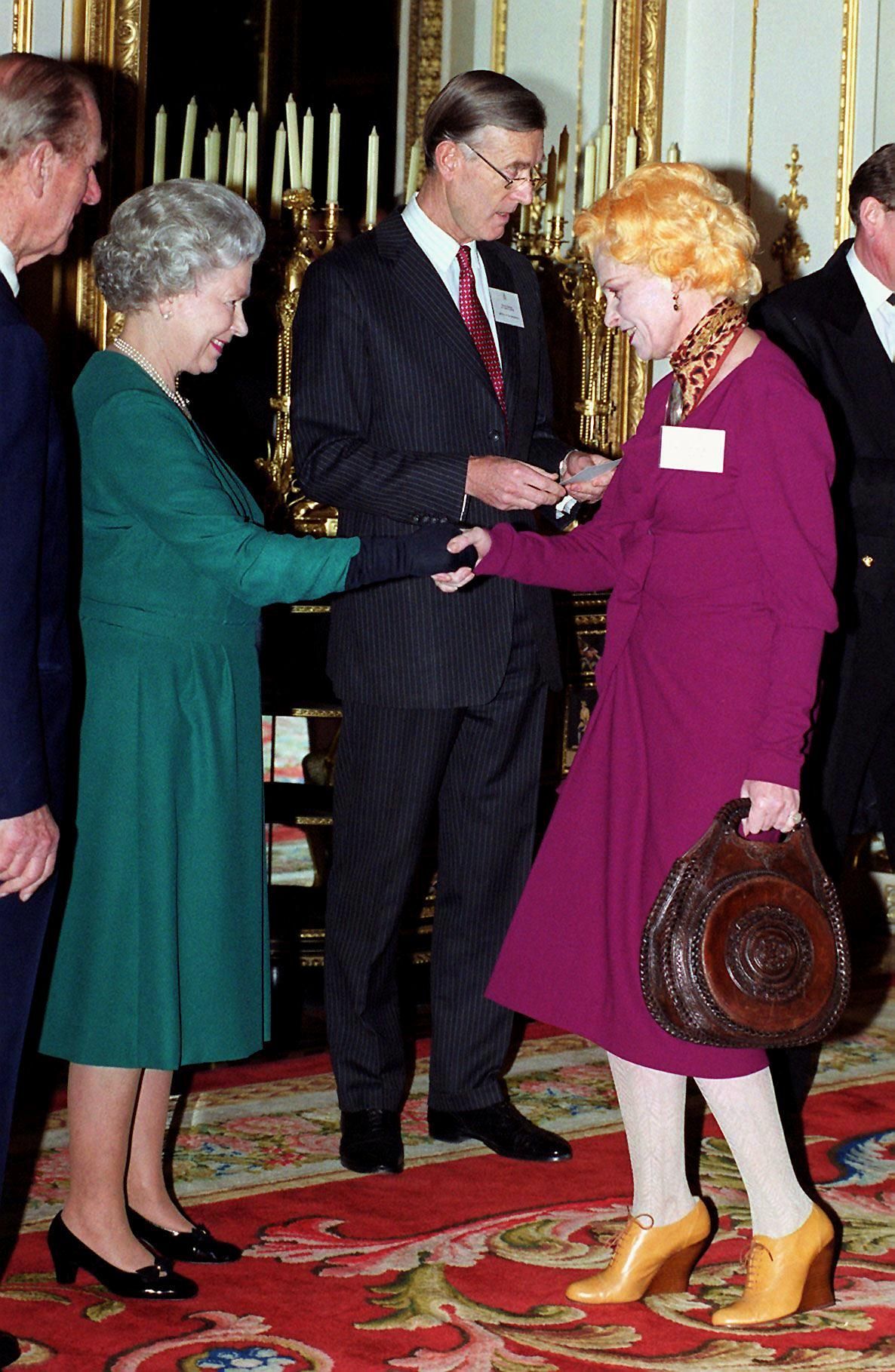 (FILES) In this file photo taken on March 1, 1999 British Queen Elizabeth II (L) meets celebrated British designer Vivienne Westwood at a reception for Awards for Export, Technological and Environmental Achievement at the Buckingham Palace in London. - British fashion designer Vivienne Westwood died in London on December 29, 2022 at the age of 81, her family said. 