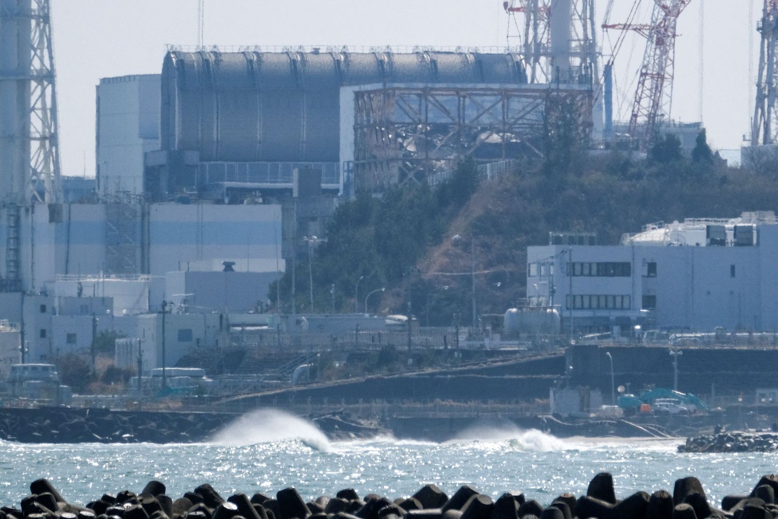 (FILES) This file photo taken on March 10, 2021 along the coast of Futaba in Fukushima prefecture shows the Tokyo Electric Power Company Holdings' (TEPCO) Fukushima Daiichi nuclear power plant (top). - The International Atomic Energy Agency said on February 18, 2022 it has made 