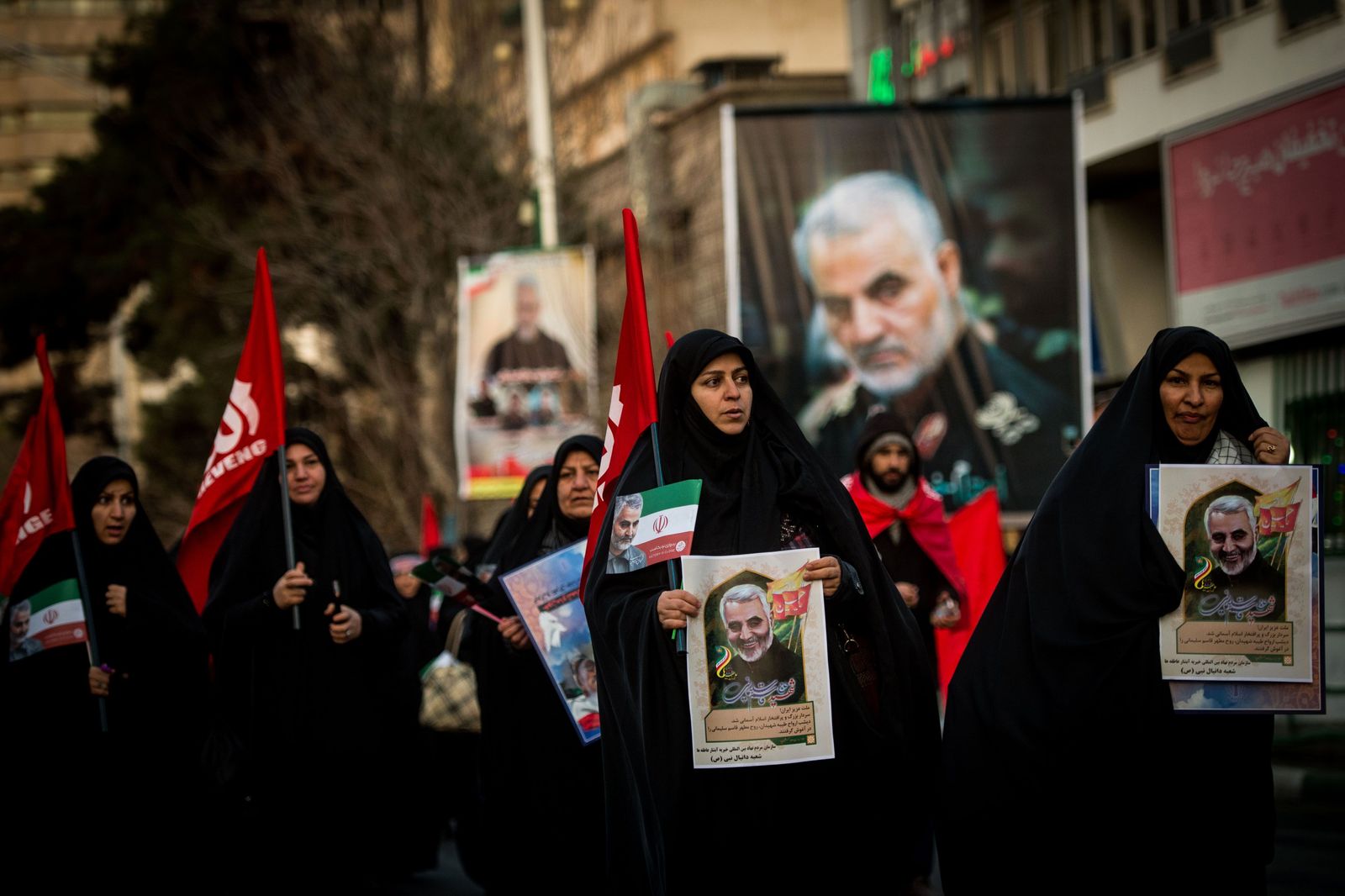 يحملن صوراً للجنرال قاسم سليماني خلال تشييعه في طهران - 6 يناير 2020 - Bloomberg