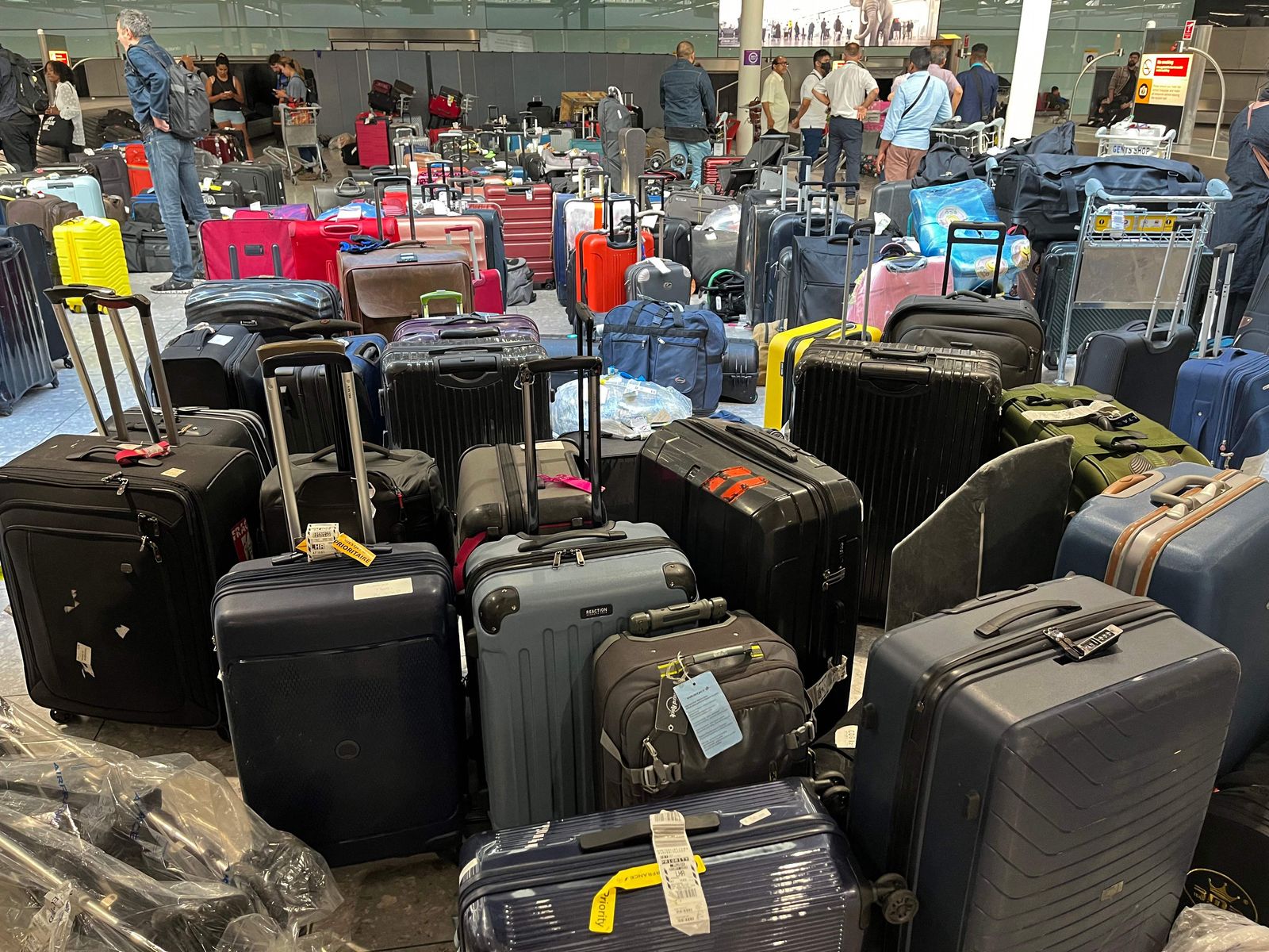 Suitcases are seen uncollected at Heathrow's Terminal Three bagage reclaim, west of London on July 8, 2022. - British Airways on Wednesday axed another 10,300 short-haul flights up to the end of October, with the aviation sector battling staff shortages and booming demand as the pandemic recedes. (Photo by Paul ELLIS / AFP) - AFP