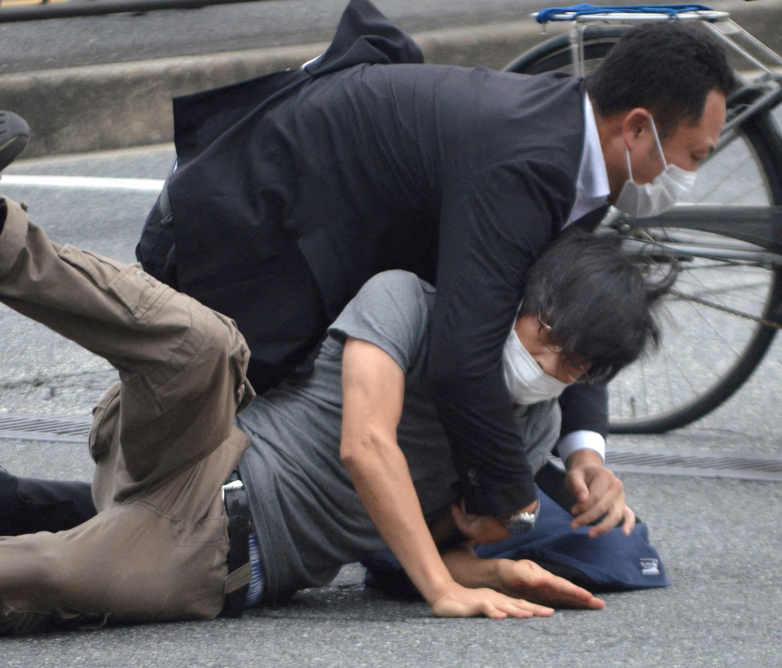 رجل أمن يحاول السيطرة على المتهم بإطلاق النار على رئيس الوزراء الياباني السابق شينزو آبي في مدينة نارا غربي البلاد - 8 يوليو 2022 - via REUTERS