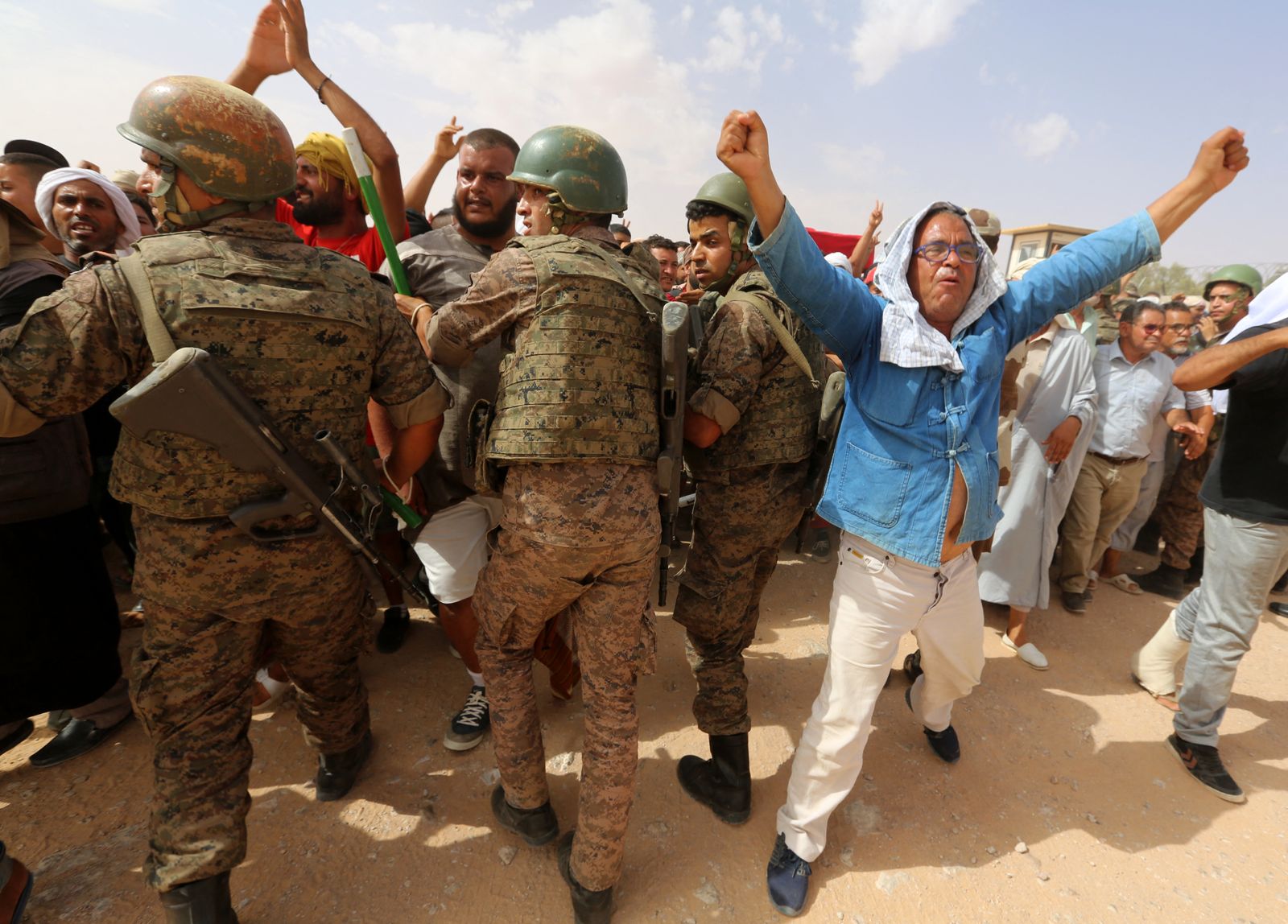 متظاهرون تونسيون يحاولون تجاوز عناصر الجيش للوصول إلى منشأة للنفط والغاز في الكمور بولاية تطاوين جنوبي تونس، 16 يوليو 2020 - AFP