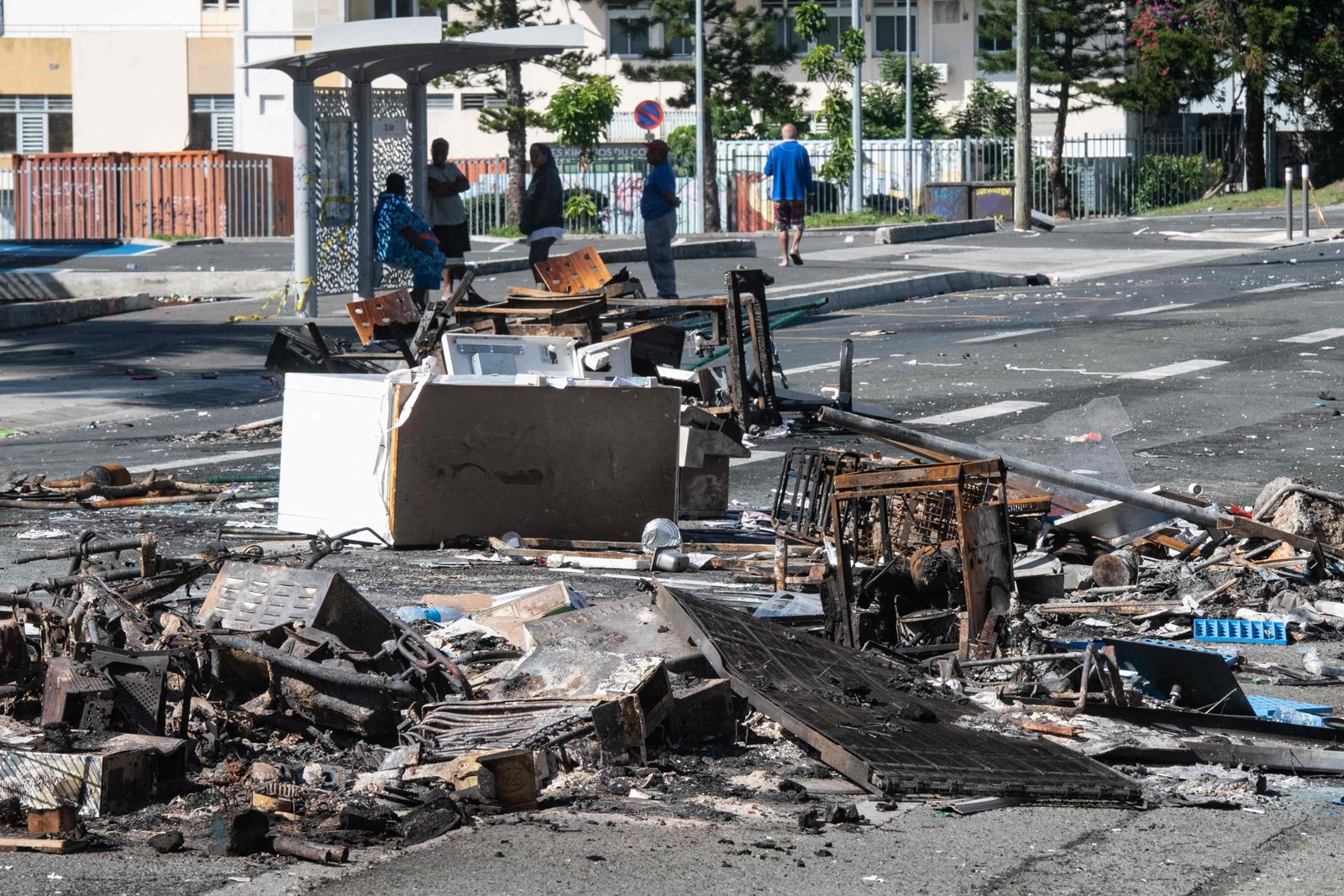 A street blocked by debris and burnt out items is seen following overnight unrest in the Magenta district of Noumea, France's Pacific territory of New Caledonia, on May 18, 2024. Hundreds of French security personnel tried to restore order in the Pacific island territory of New Caledonia on May 18, after a fifth night of riots, looting and unrest. (Photo by Delphine Mayeur / AFP)