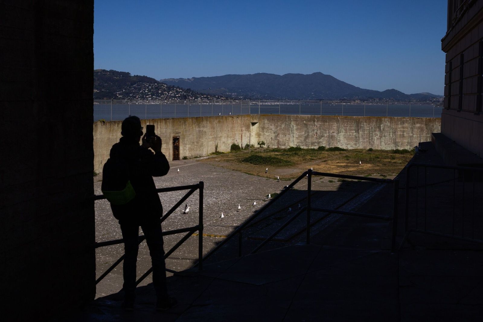 A visitor takes a photo on Alcatraz Island in San Francisco, California, US, on Monday, May 5, 2025. President Donald Trump said in a Truth Social post on Sunday that he has ordered the reopening of Alcatraz as a prison to 'house America's most ruthless and violent Offenders.' Photographer: Ethan Swope/Bloomberg
