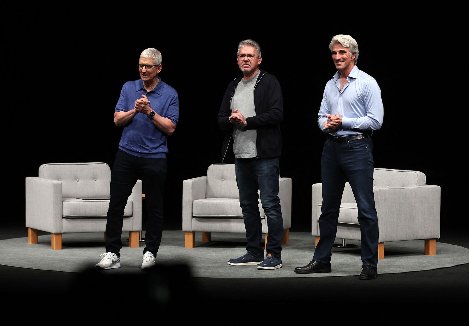CUPERTINO, CALIFORNIA - JUNE 10: (L-R) Apple CEO Tim Cook, Apple senior vice president of machine learning and AI strategy John Giannandrea and Apple senior vice president of software engineering Craig Federighi look on during the Apple Worldwide Developers Conference (WWDC) on June 10, 2024 in Cupertino, California. Apple will announce plans to incorporate artificial intelligence (AI) into Apple software and hardware.   Justin Sullivan/Getty Images/AFP (Photo by JUSTIN SULLIVAN / GETTY IMAGES NORTH AMERICA / Getty Images via AFP)