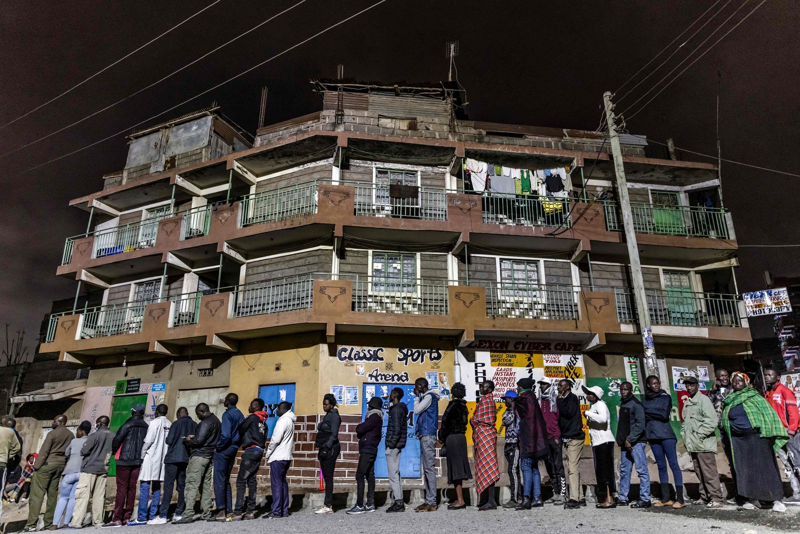 A group of voters queue while waiting for polls to open during Kenya's general election at St. Stephen School polling station in the informal settlement of Mathare in Nairobi, Kenya, on August 9, 2022. (Photo by Luis Tato / AFP) - AFP