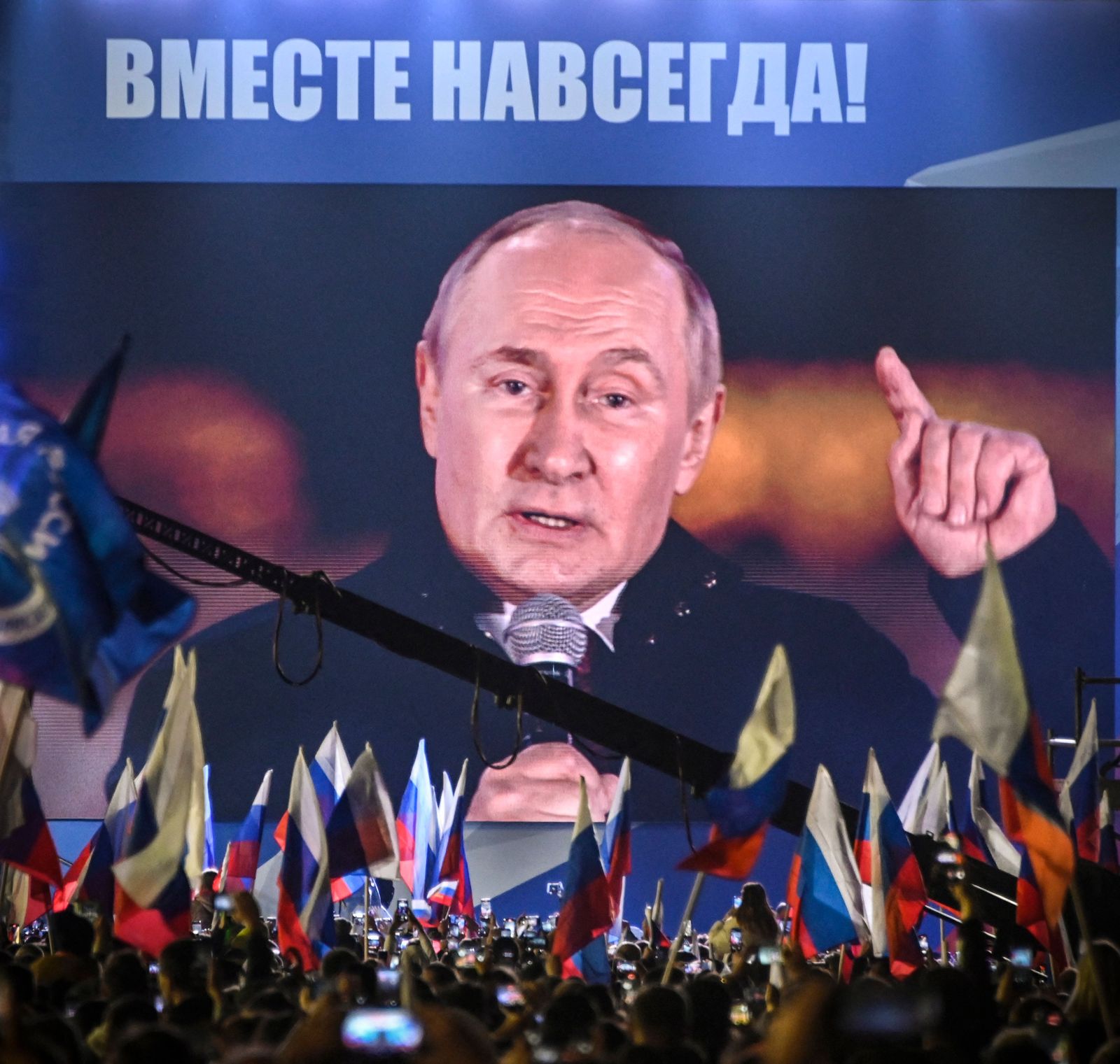 Russian President Vladimir Putin is seen on a screen set at Red Square as he addresses a rally and a concert marking the annexation of four regions of Ukraine Russian troops occupy - Lugansk, Donetsk, Kherson and Zaporizhzhia, in central Moscow on September 30, 2022. (Photo by Alexander NEMENOV / AFP) - AFP