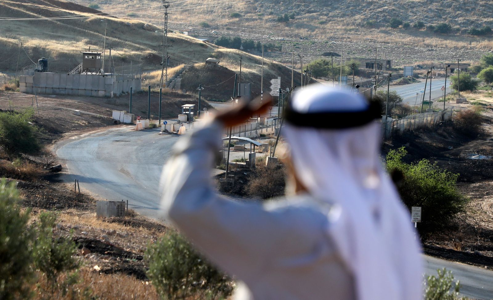 راعي فلسطيني يقف بالقرب من حاجز الحمرا الإسرائيلي، الذي يفصل مناطق السلطة الفلسطينية المصنفة A و B في غور الأردن شرقي نابلس في 1 يوليو 2020 - AFP
