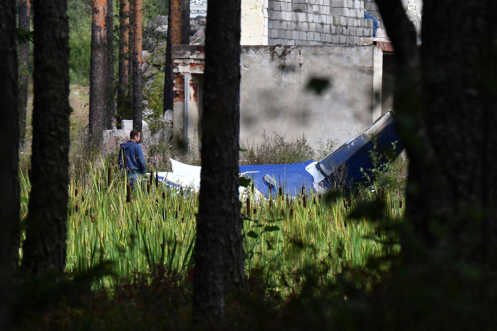 A law enforcement officer works at the site of a plane crash near the village of Kuzhenkino, Tver region, on August 24, 2023. Russian state-run news agencies on August 23, 2023 said that Yevgeny Prigozhin, the head of the Wagner group that led a mutiny against Russia's army in June, was on the list of passengers of a plane that crashed near the village of Kuzhenkino in the Tver region. (Photo by Olga MALTSEVA / AFP) - AFP