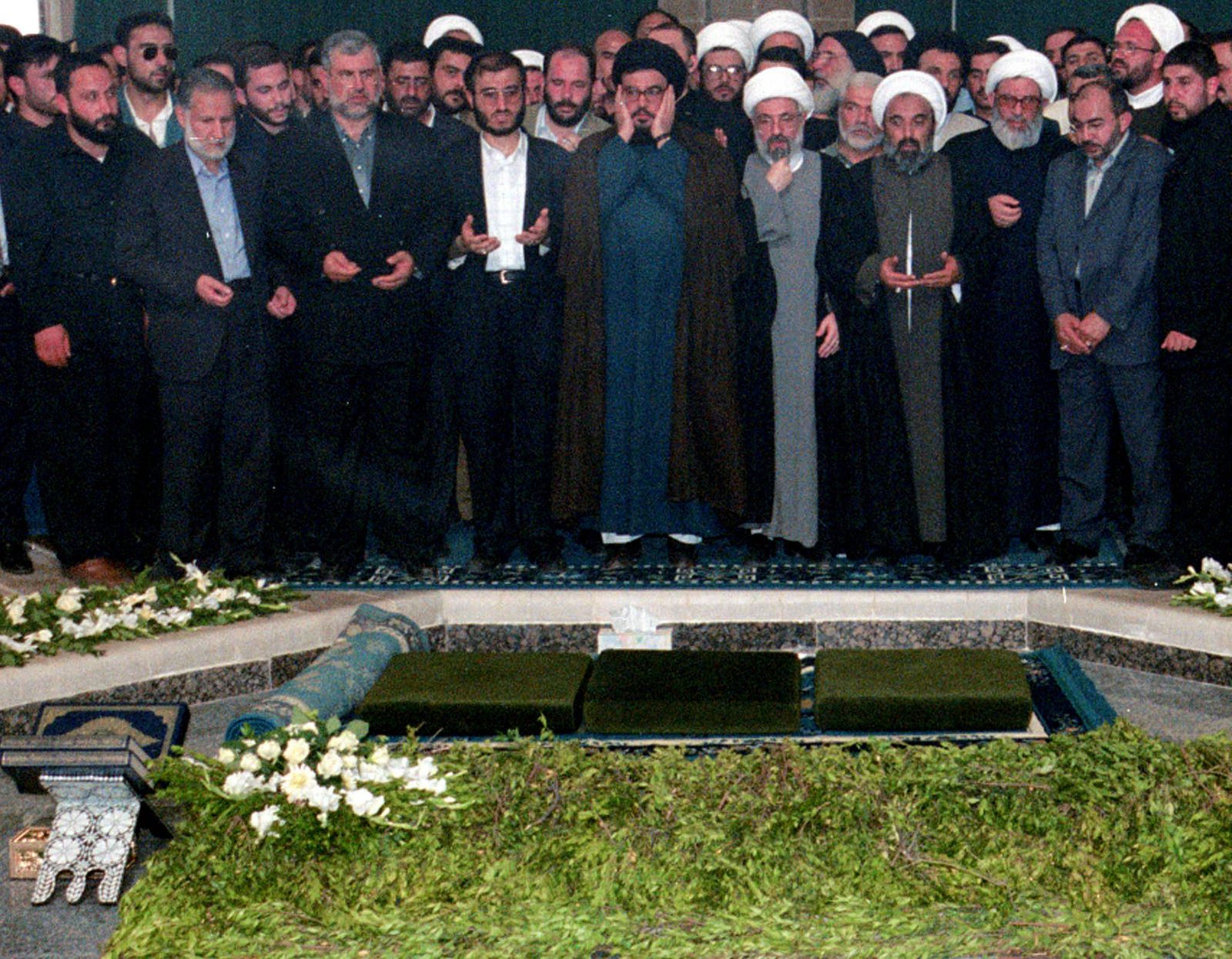 زعيم حزب الله اللبناني حسن نصر الله خلال زيارة لضريح حافظ الأسد بمدينة القرداحة على الساحل السوري- 15 يونيو 2000 - Reuters