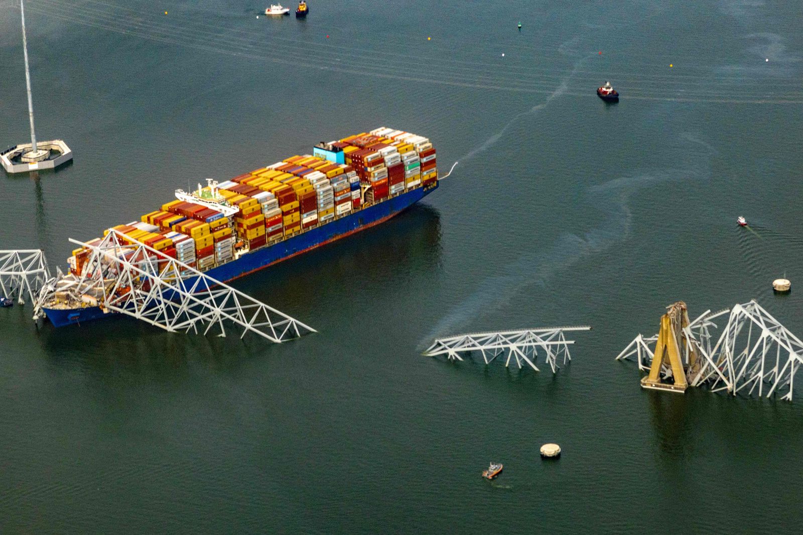 BALTIMORE, MARYLAND - MARCH 26: In an aerial view, the cargo ship Dali sits in the water after running into and collapsing the Francis Scott Key Bridge on March 26, 2024 in Baltimore, Maryland. According to reports, rescuers are still searching for multiple people, while two survivors have been pulled from the Patapsco River. A work crew was fixing potholes on the bridge, which is used by roughly 30,000 people each day, when the ship struck at around 1:30am on Tuesday morning. The accident has temporarily closed the Port of Baltimore, one of the largest and busiest on the East Coast of the U.S.   Tasos Katopodis/Getty Images/AFP (Photo by TASOS KATOPODIS / GETTY IMAGES NORTH AMERICA / Getty Images via AFP)