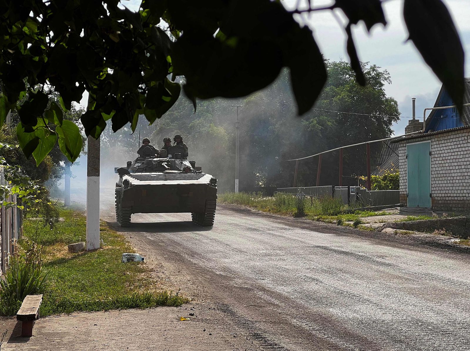 Ukrainian soldiers ride an armoured vehicle on the main road to Lysychansk in Ukraine�s eastern region of Donbas on June 26, 2022. - Russian forces achieved major military successes in eastern Ukraine on June 25, 2022, fully capturing the strategic city of Severodonetsk after a fierce battle and entering the nearby city of Lyssychansk, as the conflict entered its fifth month. (Photo by Bagus SARAGIH / AFP) - AFP