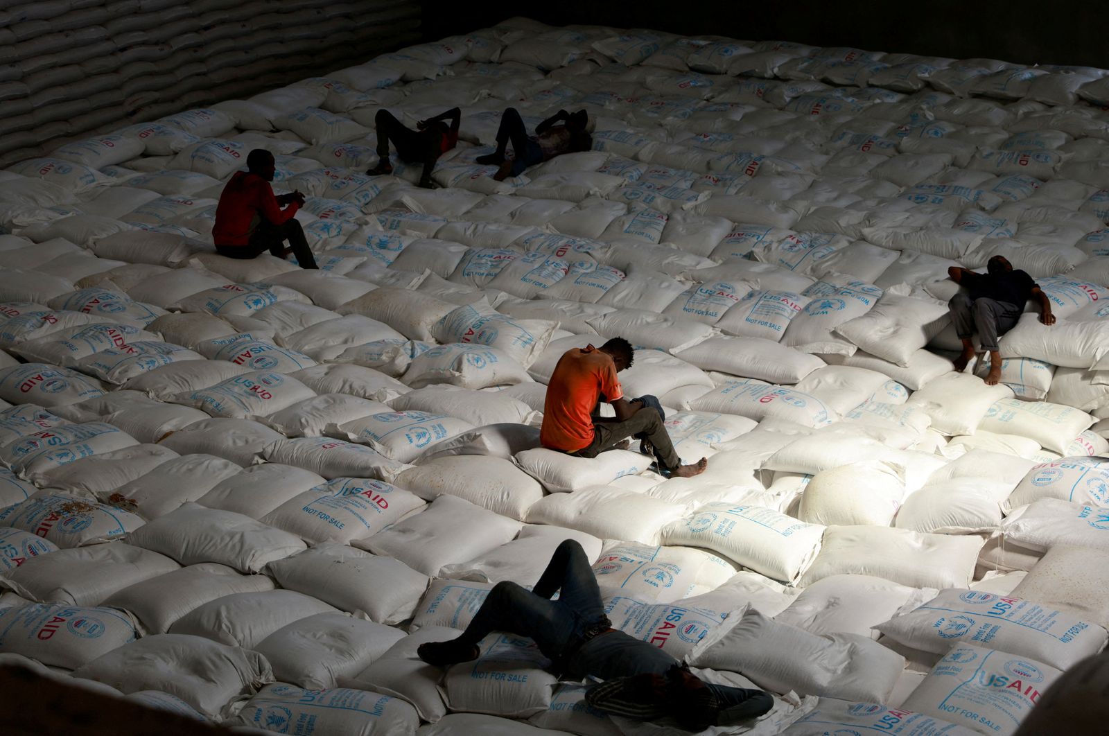 عمال يستريحون أثناء تفريغ أكياس من الحبوب كجزء من مواد الإغاثة التي تم إرسالها من أوكرانيا في مستودع برنامج الغذاء العالمي في بلدة أداما، إثيوبيا. 8  سبتمبر 2022. - REUTERS