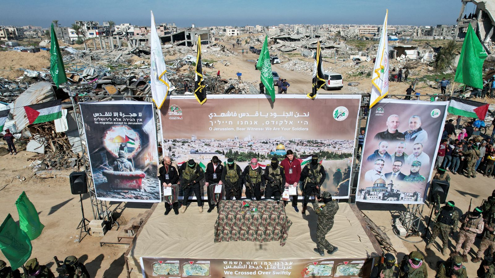 A drone view shows Palestinian Hamas and Islamic Jihad militants escorting Iair Horn, U.S.-Israeli Sagui Dekel-Chen and Russian-Israeli Sasha (Alexander) Troufanov, hostages held in Gaza since the deadly October 7, 2023 attack, as they released as part of a ceasefire and a hostages-prisoners swap deal between Hamas and Israel in Khan Younis, in the southern Gaza Strip, February 15, 2025. REUTERS/Stringer     TPX IMAGES OF THE DAY