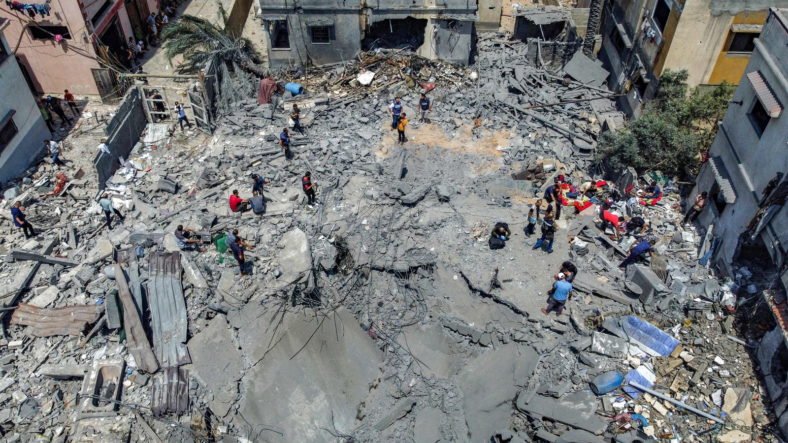 فلسطينيون يتفقدون أنقاض مبنى منهار دمرته غارة جوية إسرائيلية على مدينة غزة- 6 أغسطس 2022 - AFP