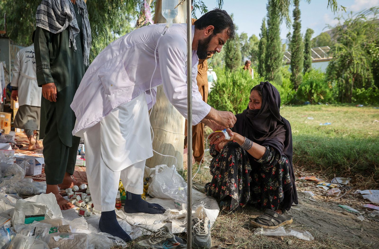 A doctor examines a victim of a deadly magnitude-6 earthquake that struck Afghanistan on Sunday, at a mobile clinic setup inside a school, in Nurgal district, Kunar province, Afghanistan, September 3, 2025. REUTERS/Sayed Hassib