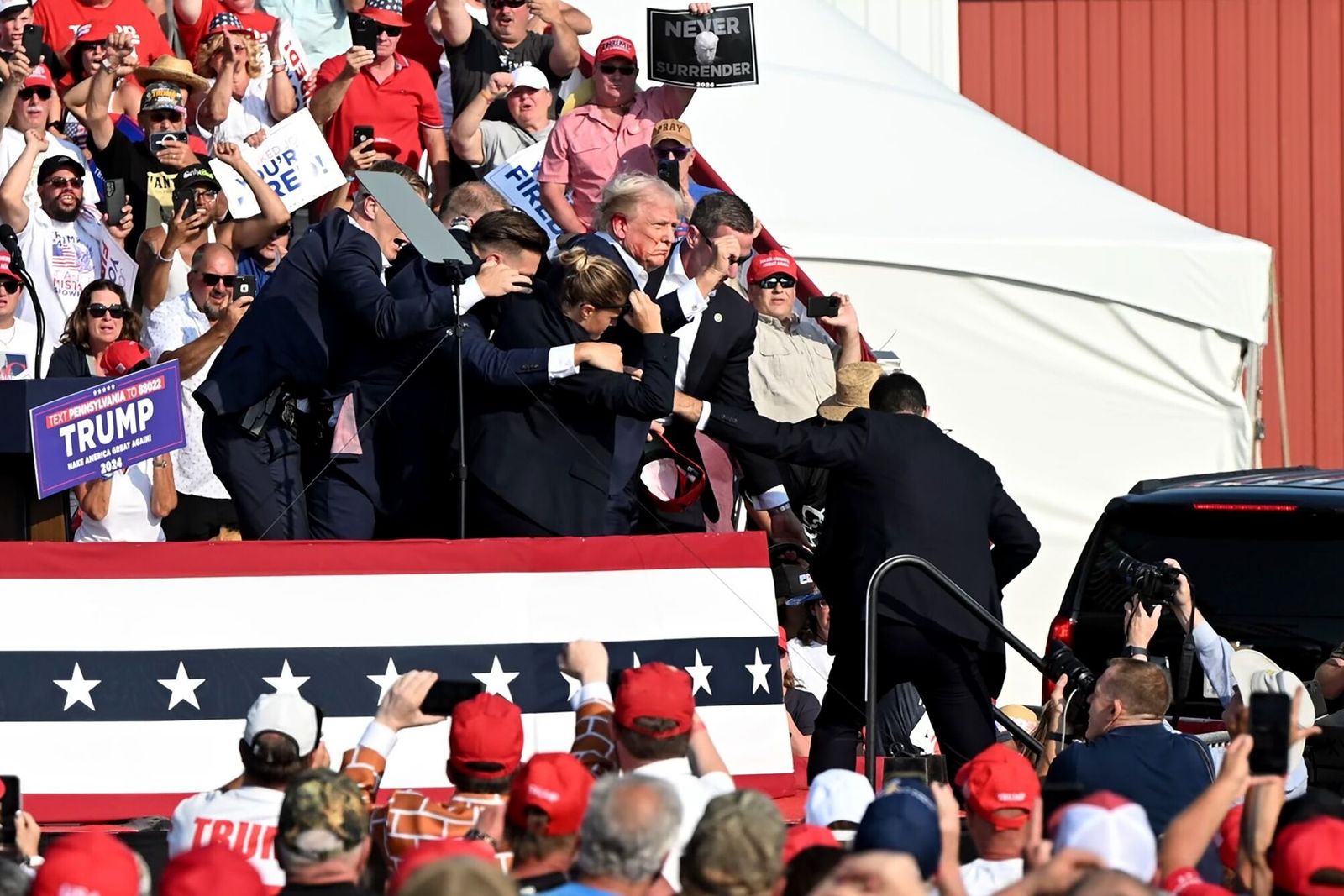 Former US President Donald Trump is surrounded by Secret Service agents during a campaign event at Butler Farm Show Inc. in Butler, Pennsylvania, US, on Saturday, July 13, 2024. Former President Donald Trump is being evaluated at a medical facility but is 'fine' after an incident where he was rushed off stage during rally in Butler, Pennsylvania, his campaign said. Photographer: Joe Appel/Bloomberg