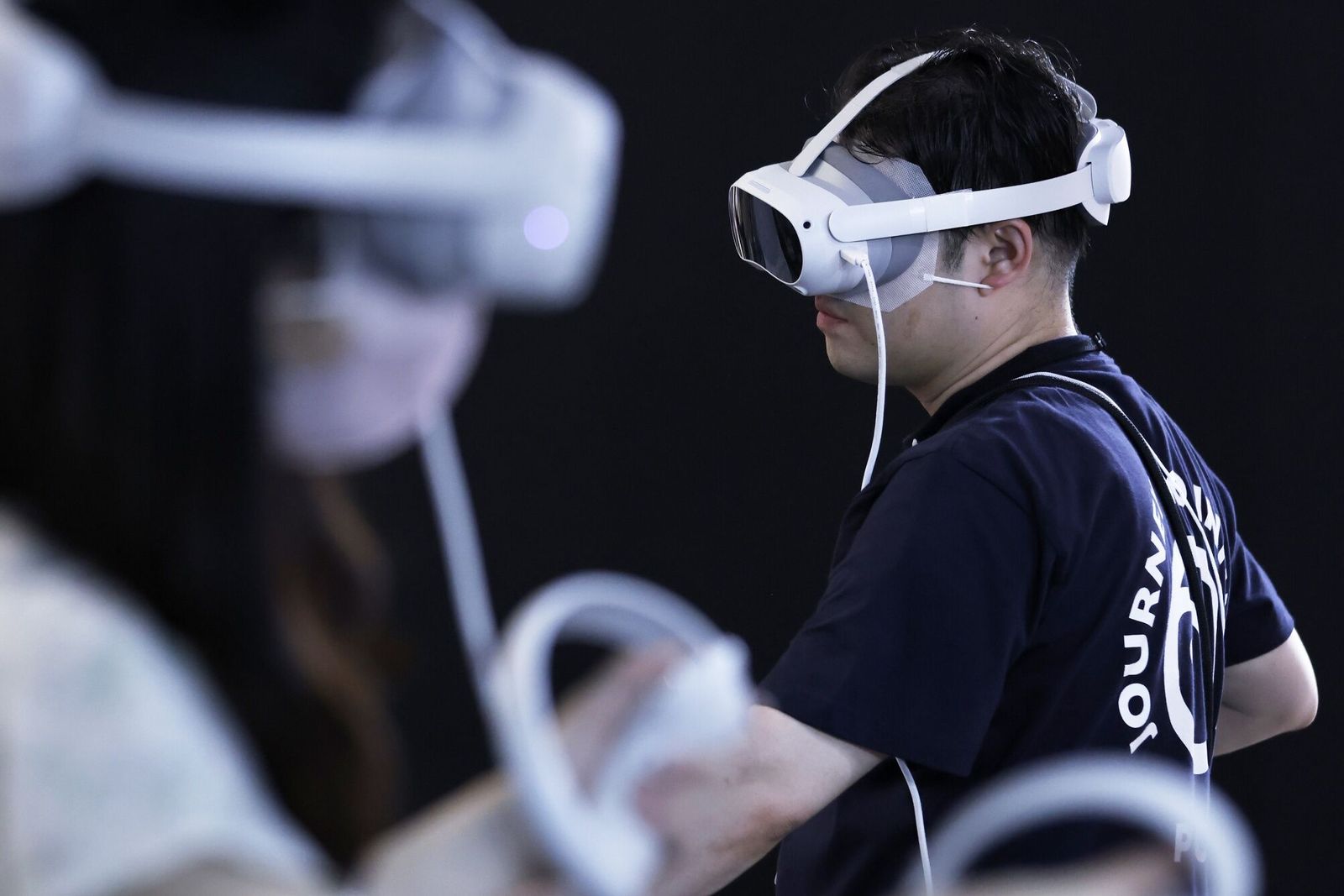 An attendant, right, wears a Pico 4 virtual reality (VR) headset in the Pico Technology Japan booth at the Tokyo Game Show in Chiba, Japan, on Thursday, Sept. 21, 2023. The show runs through to Sept. 24. Photographer: Kiyoshi Ota/Bloomberg