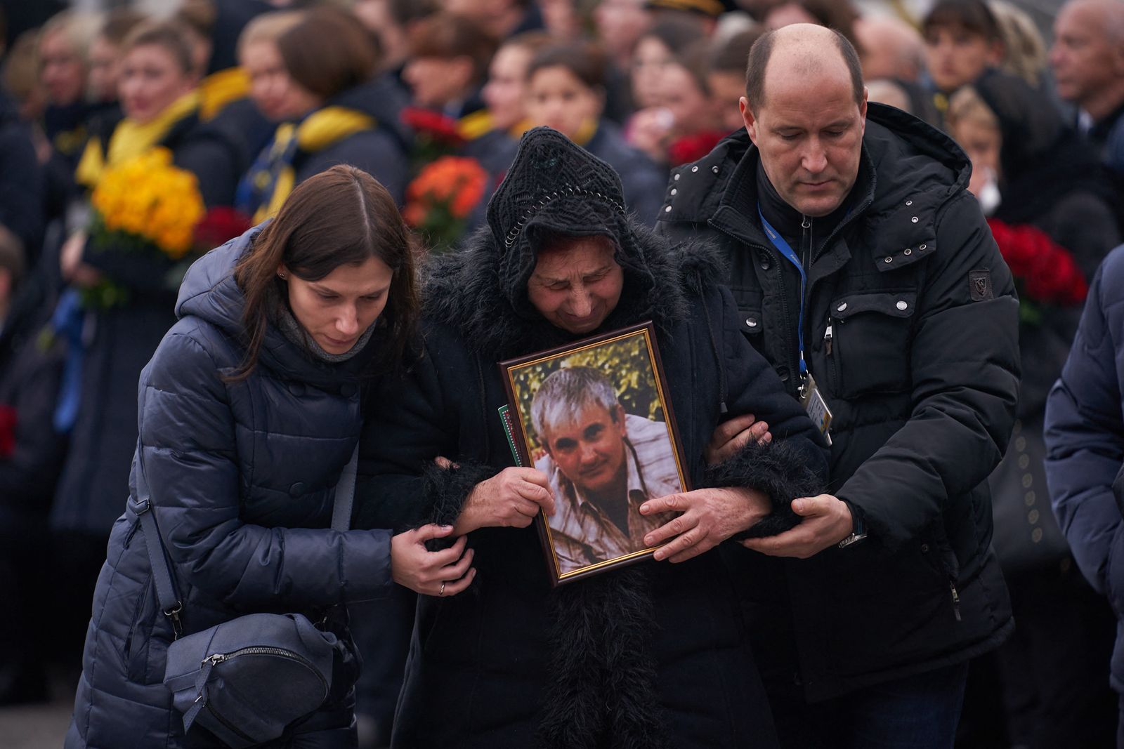 This handout picture taken and released by the Ukrainian presidential press service on January 19, 2020, shows relatives and colleagues as they attend a tribute ceremony at Kiev's Boryspil airport for the 11 Ukrainians who died in a plane mistakenly shot down by Iran during a spike in tensions with Washington. - Ukarine's President, Prime Minister and other officials attend the solemn ceremony at Kiev's Boryspil airport to see caskets with the remains of the downed plane's nine Ukrainian flight crew and two passengers being removed from the aircraft. (Photo by UKRAINIAN PRESIDENTIAL PRESS SERVICE / AFP) / RESTRICTED TO EDITORIAL USE - MANDATORY CREDIT 