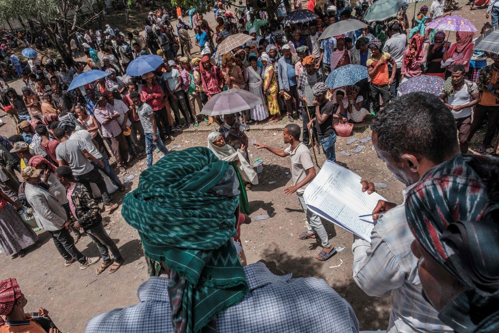 People gather as government personnel organise a food distribution in Ataye, Ethiopia, on May 15, 2021. - More than 100 civilians died in a recent flare-up of violence in the town of Ataye that also saw the assailants torch more than 1,500 buildings.
The destruction continues a pattern of unrest that has blighted the tenure of Prime Minister Abiy Ahmed, winner of the 2019 Nobel Peace Prize, and now threatens to disrupt elections in which he'll seek a new term. 
Ethiopia's polls are scheduled for June 21, but officials say insecurity and logistical challenges make voting impossible -- at least for now -- in at least 26 constituencies across the country. (Photo by EDUARDO SOTERAS / AFP) - AFP