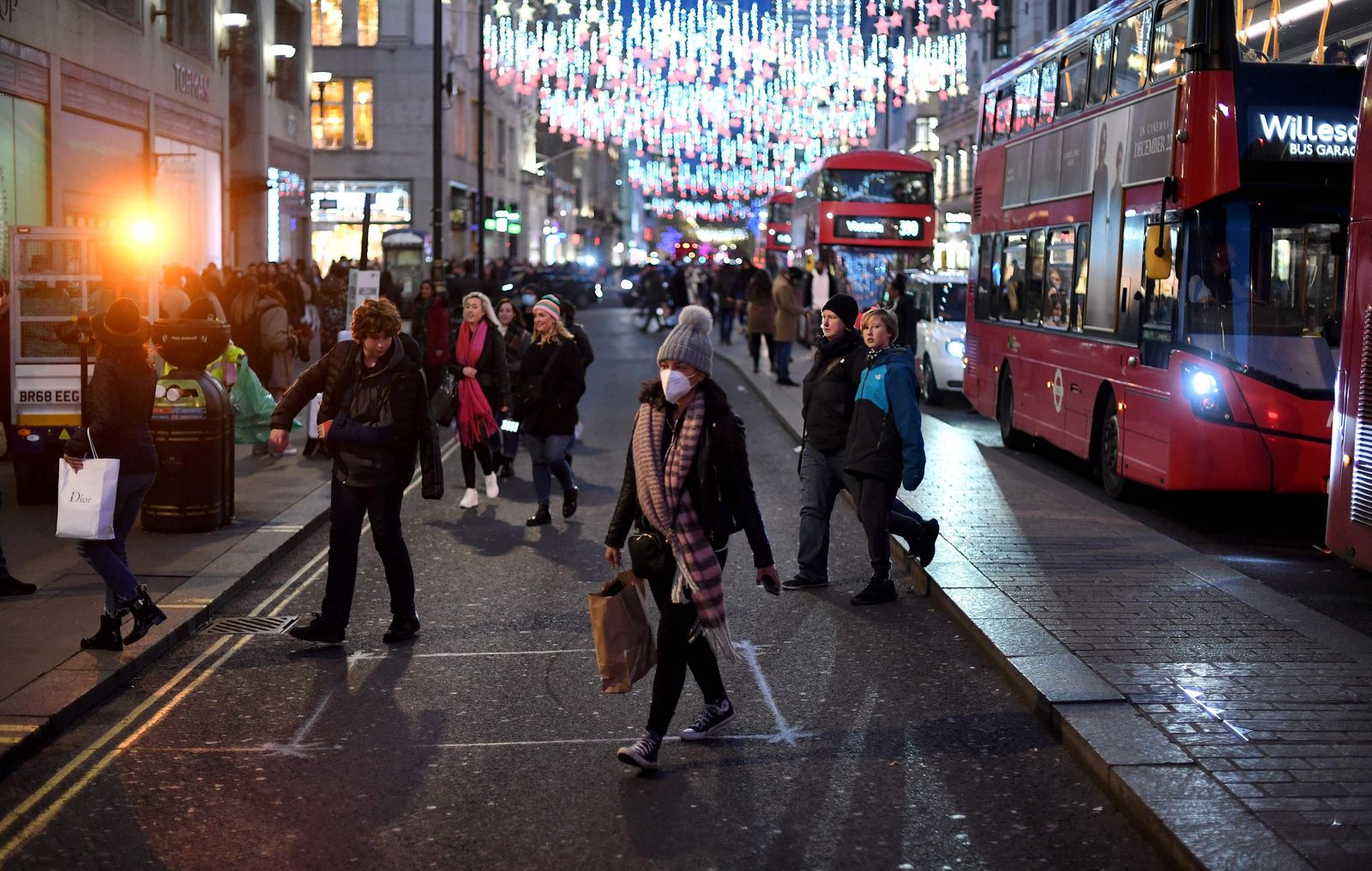 بعض المتسوقين يرتدون الكمامات، وهم يعبرون شارع أكسفورد في وسط لندن. 4 ديسمبر 2021 - AFP