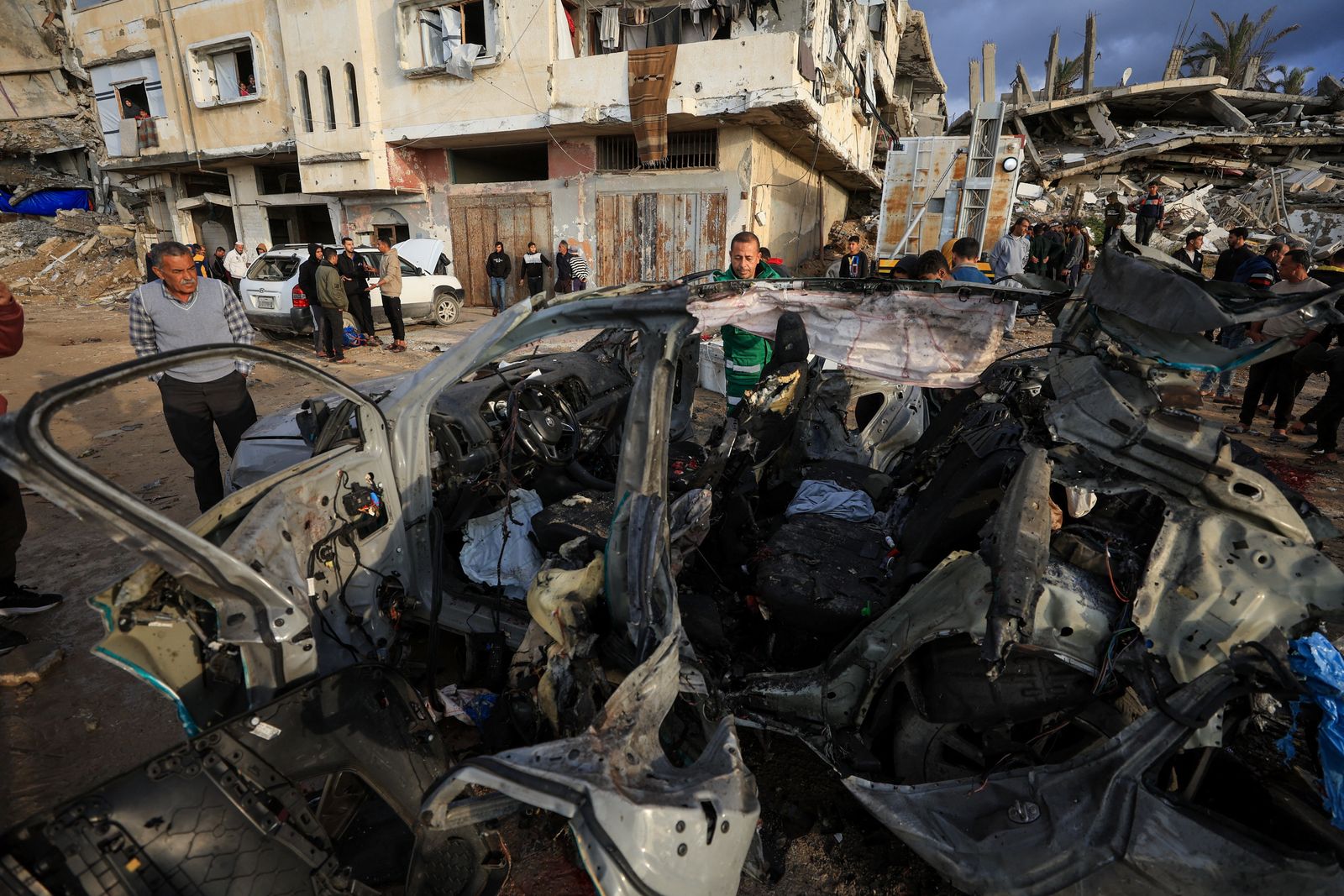 Palestinians inspect the site of an Israeli strike on a car in Gaza City, December 13, 2025.REUTERS/Dawoud Abu Alkas