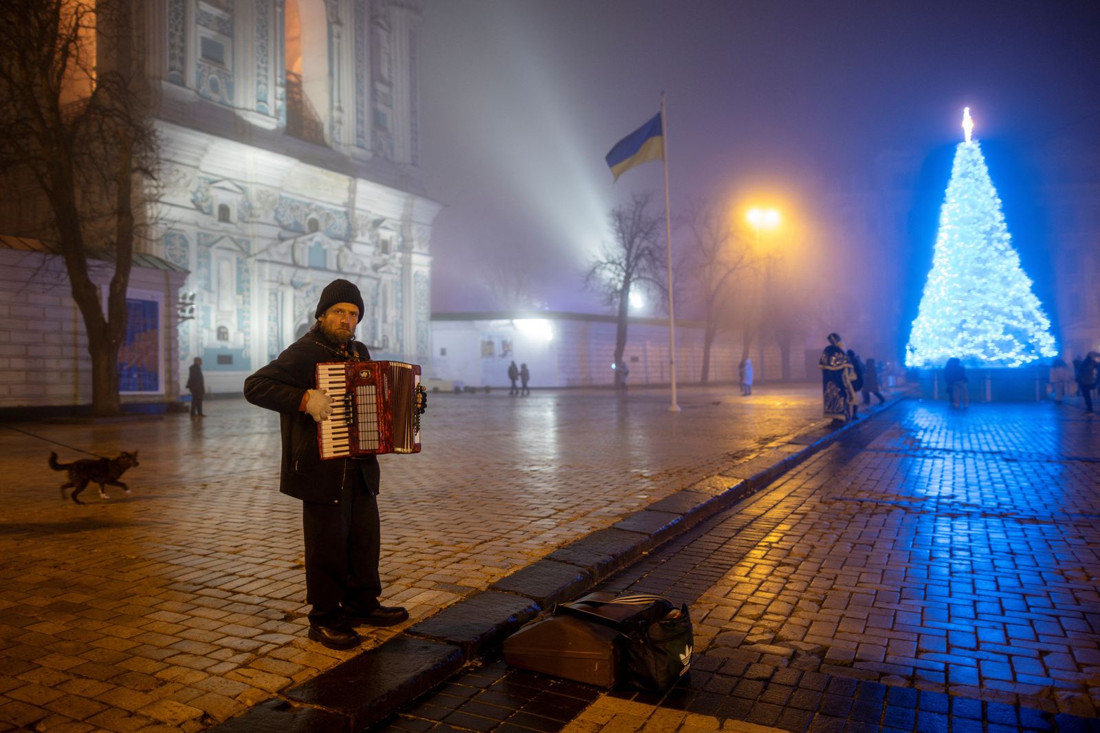 A man plays the accordion near Ukraine's main Christmas tree in Sophia Square on Christmas Eve, amid Russia's attack on Ukraine, in Kyiv, Ukraine, December 24, 2024.  REUTERS/Thomas Peter