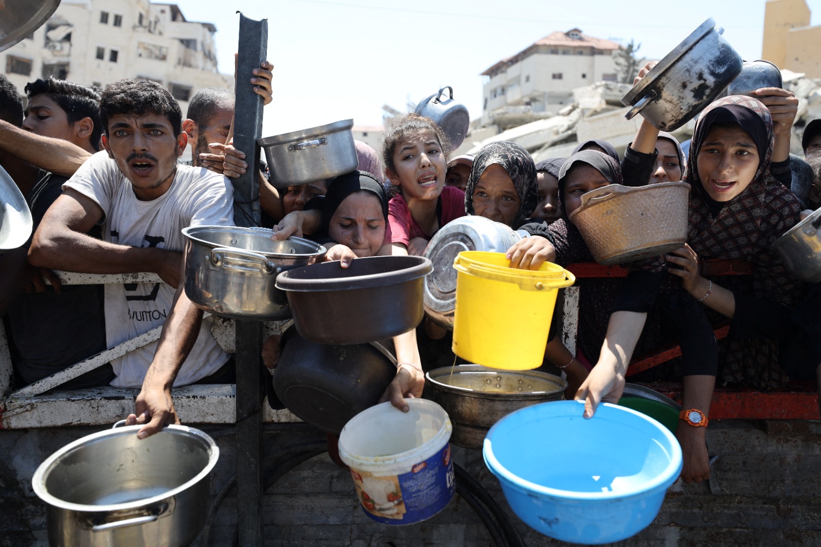 فلسطينيون ينتظرون الحصول على طعام من مطبخ خيري وسط أزمة جوع يفرضها الحصار الإسرائيلي في مدينة غزة. 24 يوليو 2025