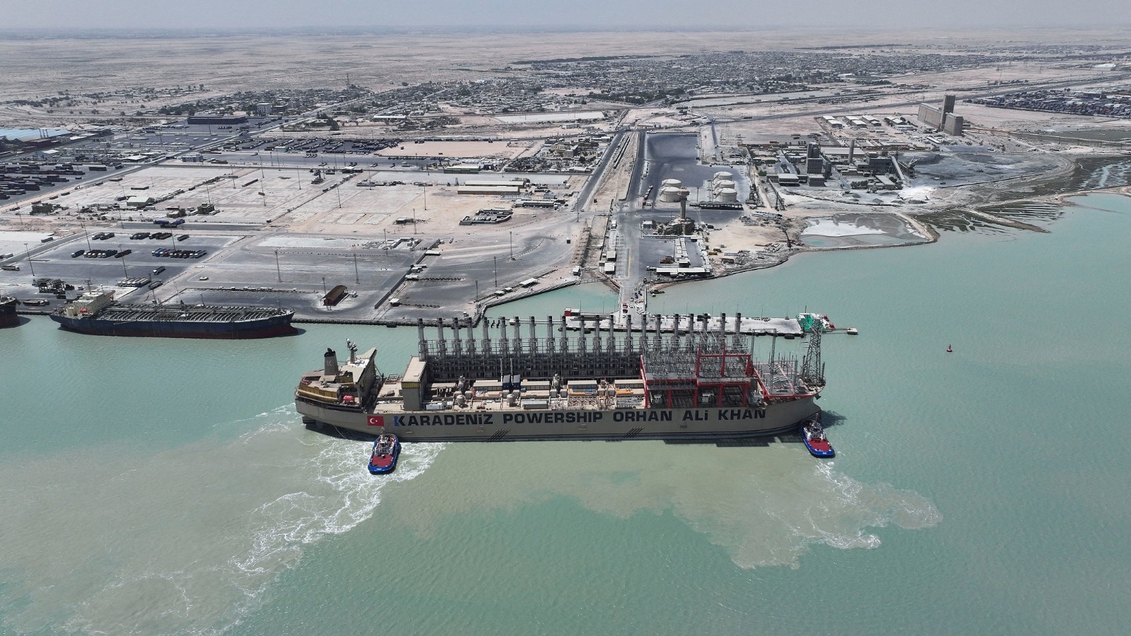 صورة ملتقطة بطائرة مسيّرة لسفينة الطاقة العائمة 'كارادينيز باورشيب أورهان علي خان' (Karadeniz Powership Orhan Ali Khan)، وهي راسية في ميناء أم قصر بمحافظة البصرة في العراق، بتاريخ 21 أغسطس 2025. وكانت شركة 'كارباورشيب' (Karpowership) قد وقّعت اتفاقاً لتزويد العراق بما يصل إلى 590 ميغاواط من الكهرباء لمدة 71 يوماً.