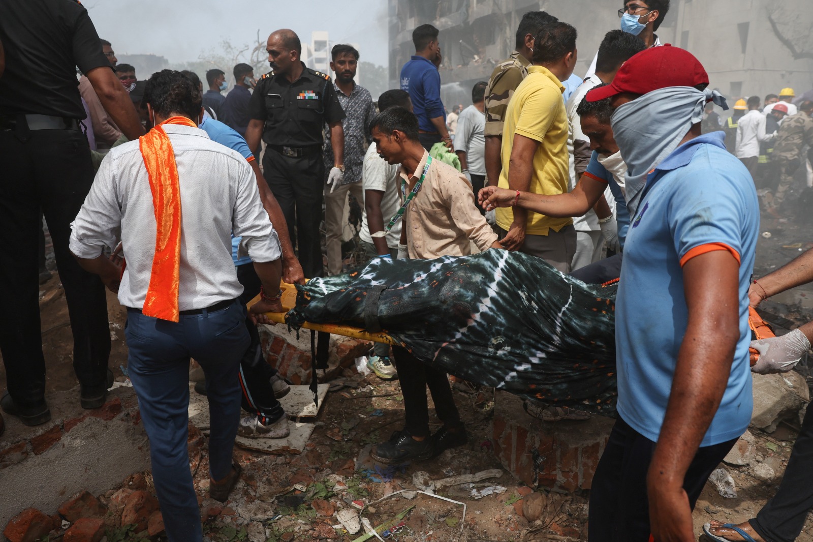 أشخاص يحملون جثة ضحية من موقع تحطم طائرة في الهند. 12 يونيو 2025