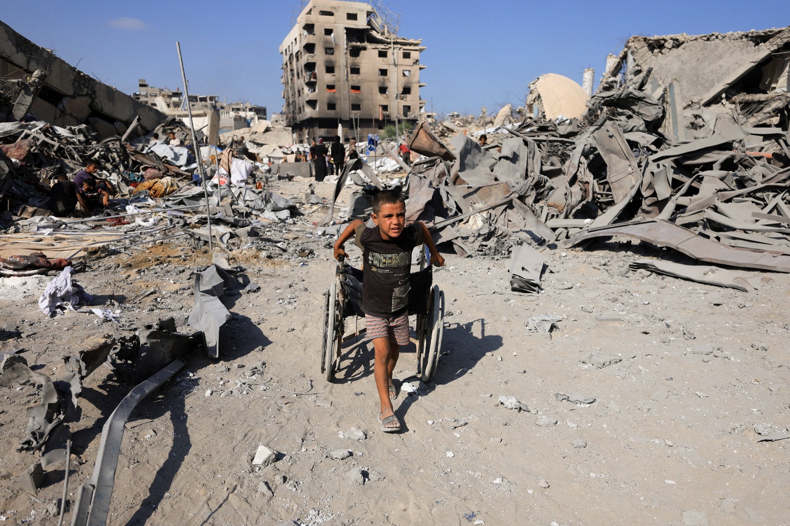 صبي فلسطيني يسحب كرسياً متحركاً في موقع محيط بعيادة للأونروا تم إخلاؤها في أعقاب غارة إسرائيلية في مدينة غزة. 6 أغسطس 2025